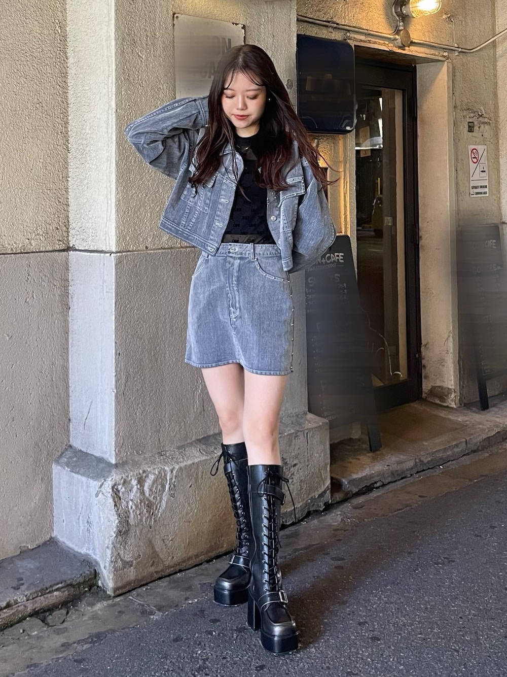 グレー系のスカート、ブラック系のブーツ、ブラック系のTシャツ/カットソーを着用したレディースの夏コーディネートの1枚目の写真