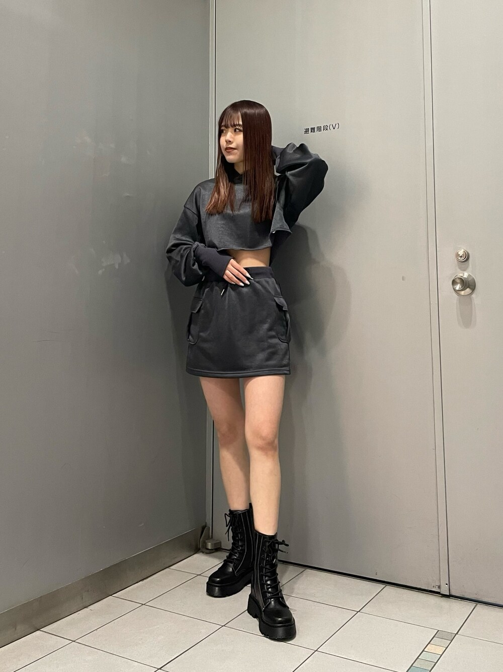 ブラック系のブーツ、グレー系のスカート、グレー系のTシャツ/カットソーを着用したレディースの冬コーディネートの1枚目の写真