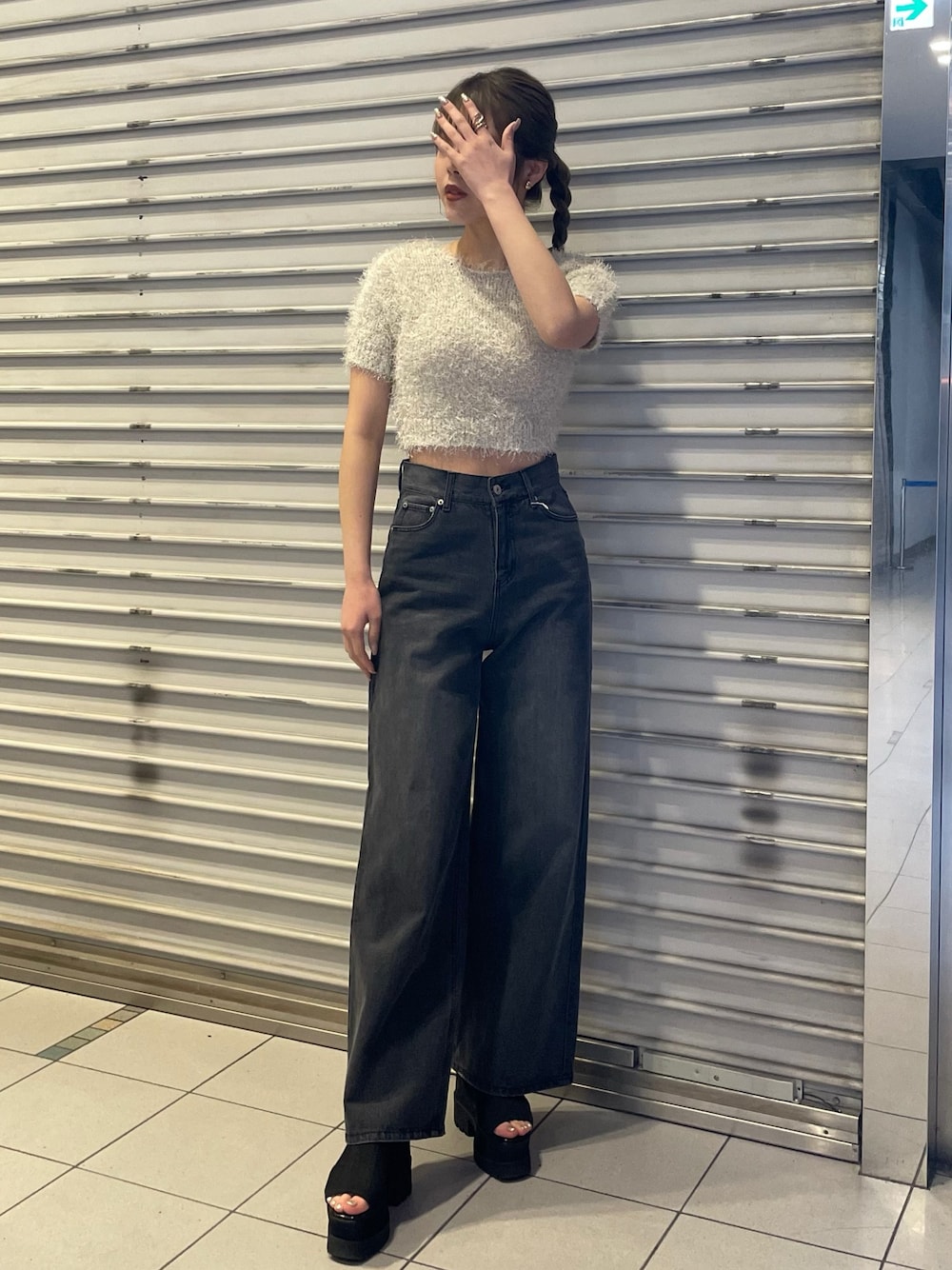 ホワイト系のニット/セーター、ブラック系のデニムパンツ、ブラック系のブーツを着用したレディースの春コーディネートの1枚目の写真