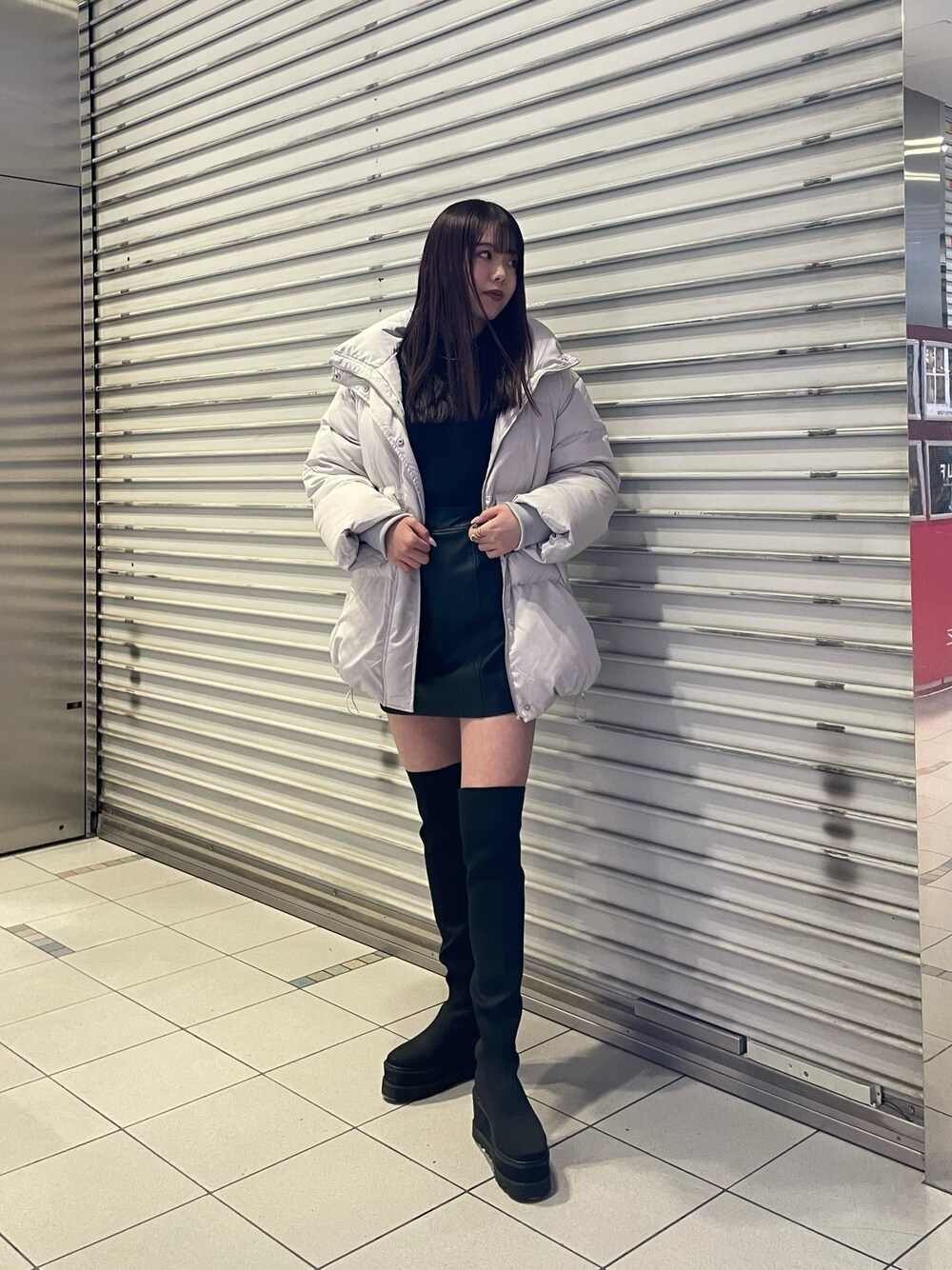 ブラック系のブーツ、ブラック系のニット/セーター、グレー系のダウンジャケット/コートを着用したレディースの冬コーディネートの1枚目の写真