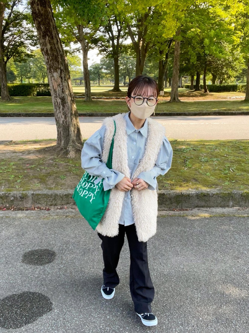 ブラック系のシャツ/ブラウス、ホワイト系のベスト、グリーン系のトートバッグを着用したレディースの秋コーディネートの1枚目の写真