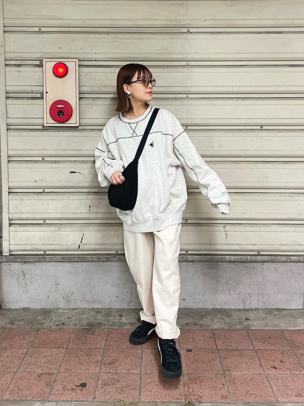 ベージュ系のスウェット、ベージュ系のデニムパンツ、ブラック系のショルダーバッグを着用したレディースの秋コーディネートの1枚目の写真
