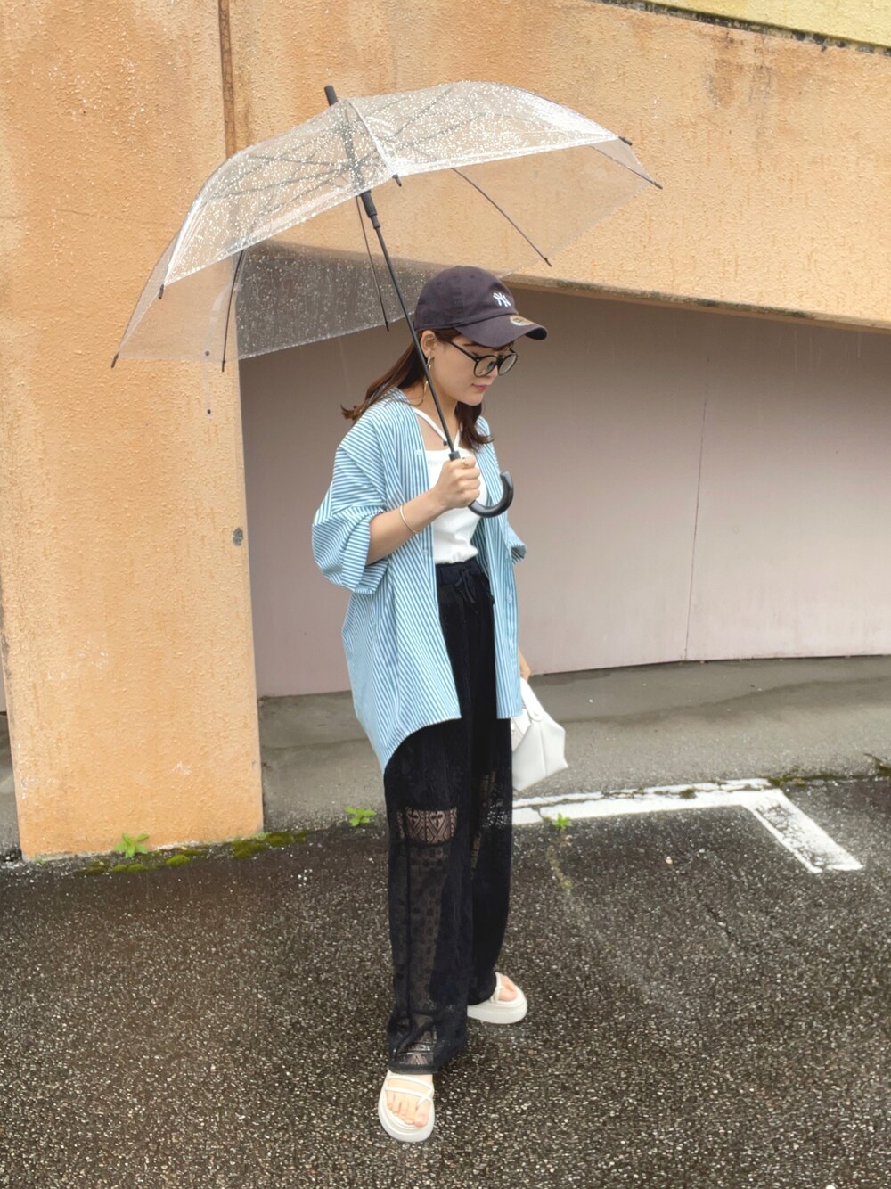 グリーン系のシャツ/ブラウス、ブラック系のその他パンツ、ホワイト系のキャミソールを着用したレディースの春コーディネートの1枚目の写真