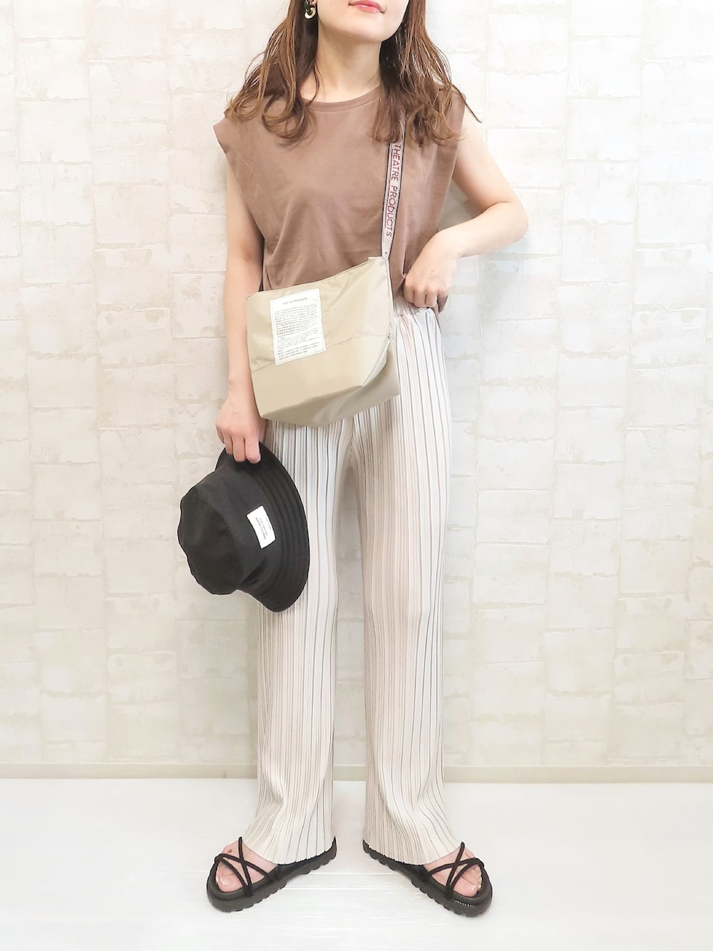 ベージュ系のショルダーバッグ、ブラウン系のTシャツ/カットソー、ホワイト系のその他パンツを着用したレディースの夏コーディネートの1枚目の写真