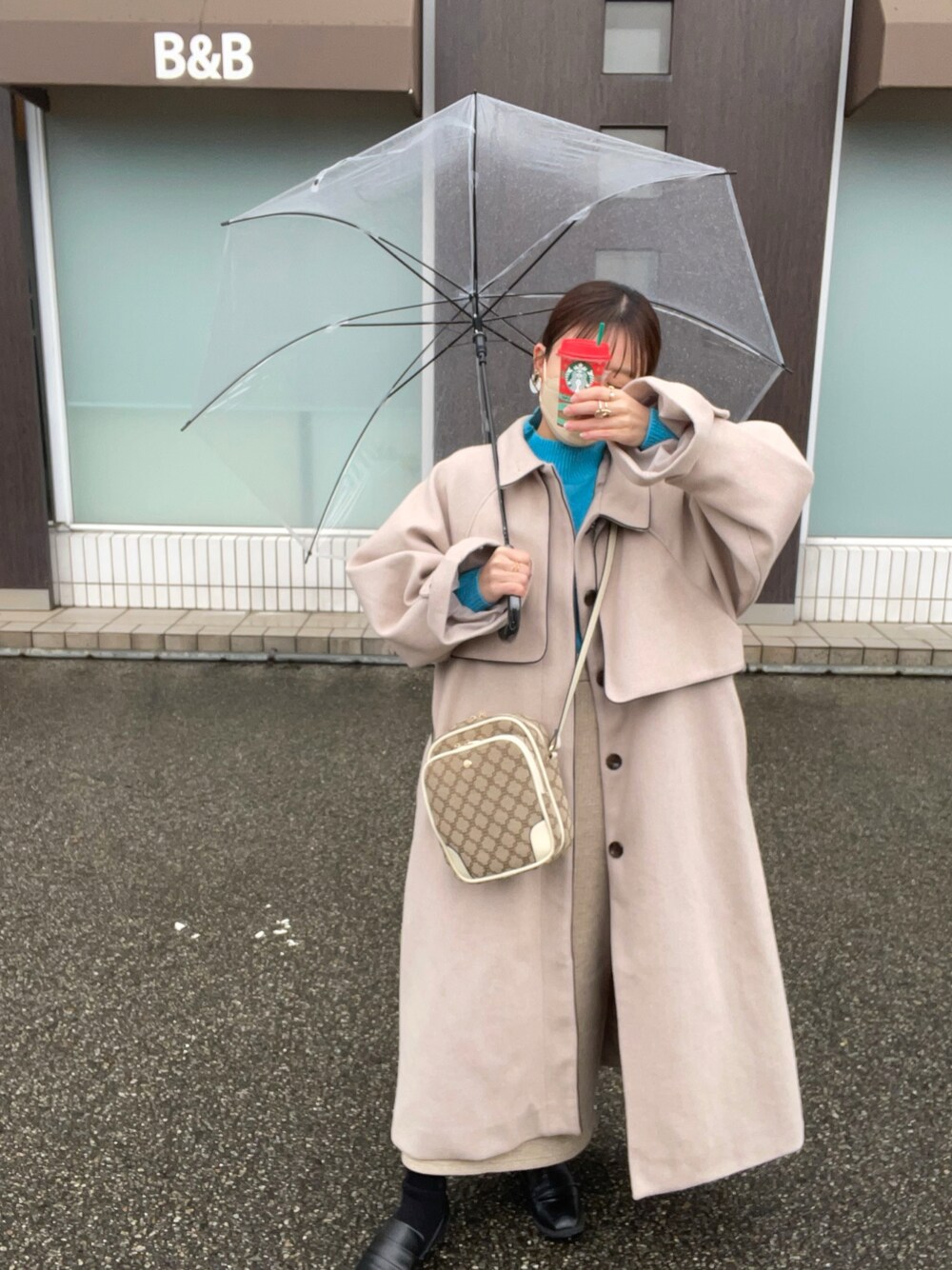 ベージュ系のショルダーバッグ、ブルー系のトップス、ベージュ系のジャケット/アウターを着用したレディースの冬コーディネートの1枚目の写真