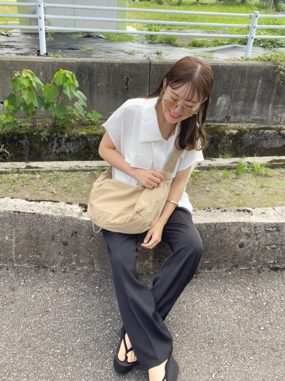 ベージュ系のショルダーバッグ、ブラック系のパンツ、ブラック系のサンダルを着用したレディースの夏コーディネートの1枚目の写真