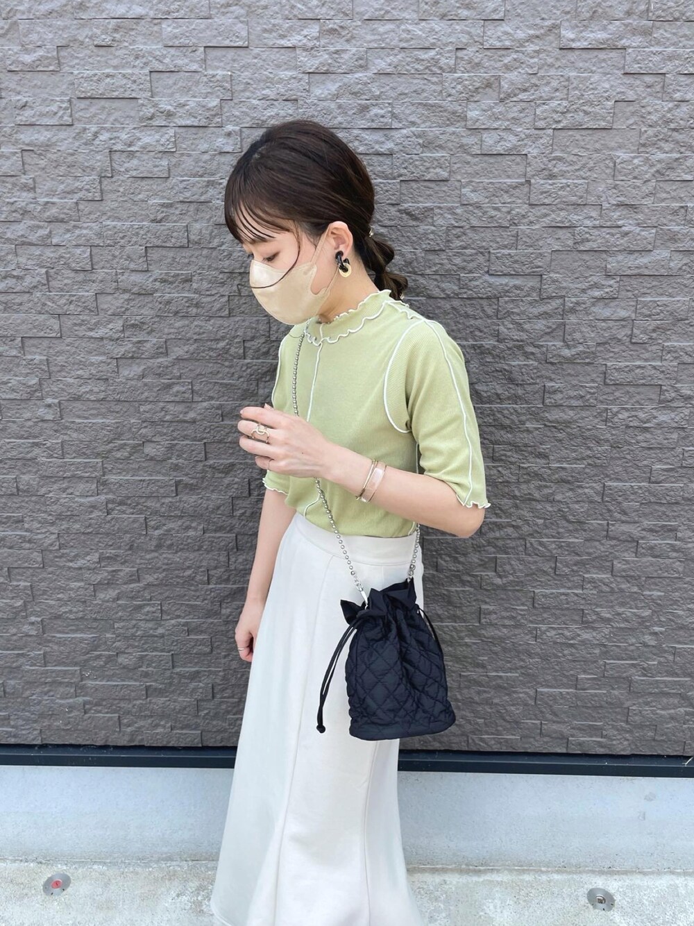 グリーン系のTシャツ/カットソー、ホワイト系のスカート、ブラック系のショルダーバッグを着用したレディースの夏コーディネートの1枚目の写真