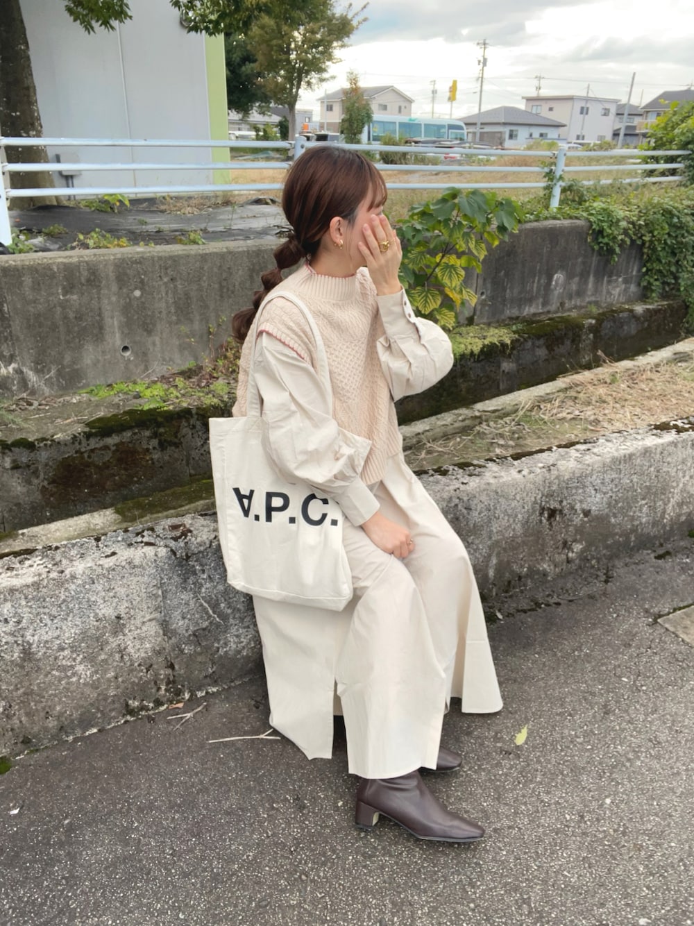 ホワイト系のベスト、ベージュ系のワンピース、ホワイト系のトートバッグを着用したレディースの秋コーディネートの1枚目の写真