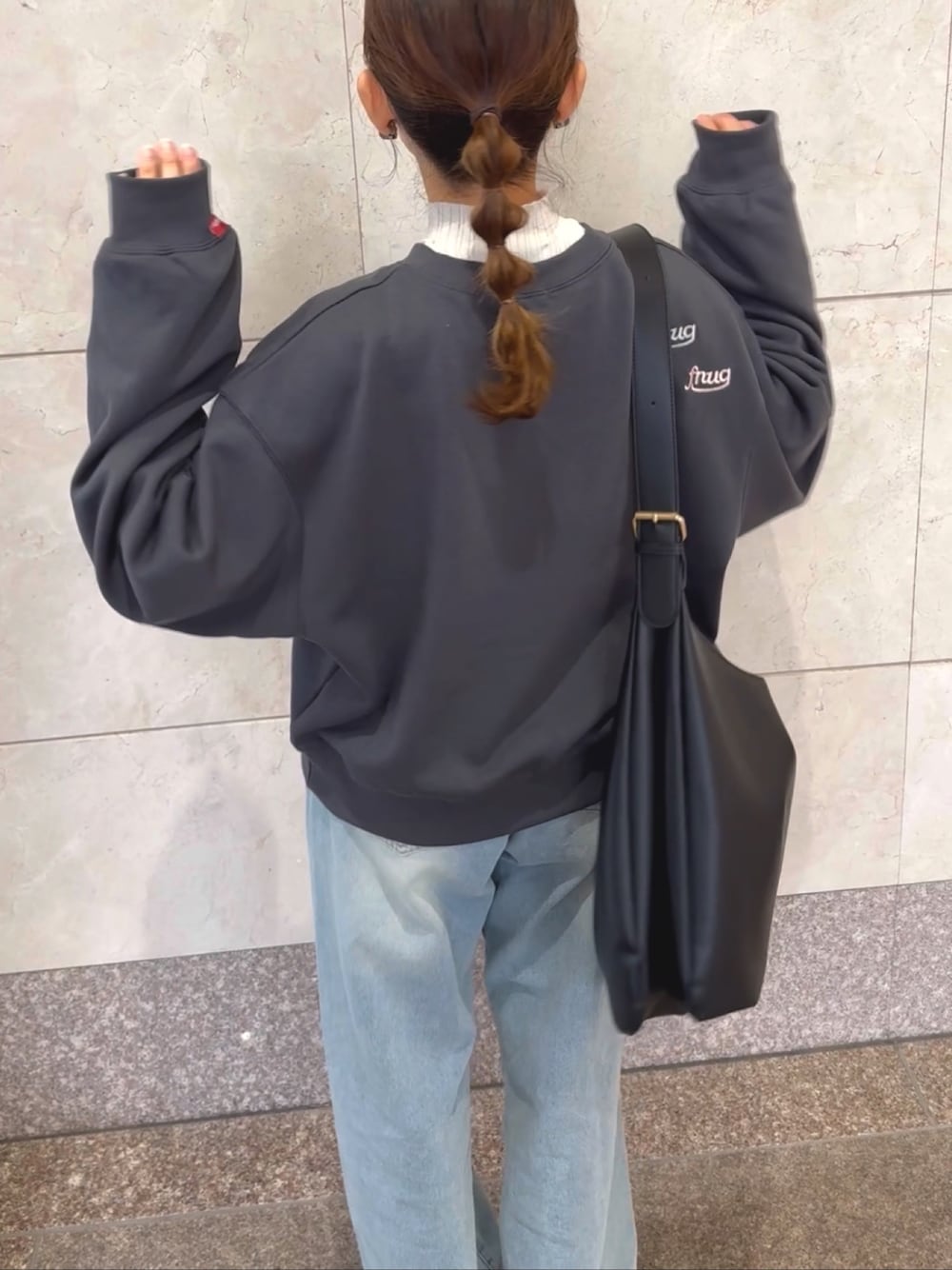 グレー系のスウェット、ホワイト系のニット/セーター、ブルー系のデニムパンツを着用したレディースの冬コーディネートの1枚目の写真