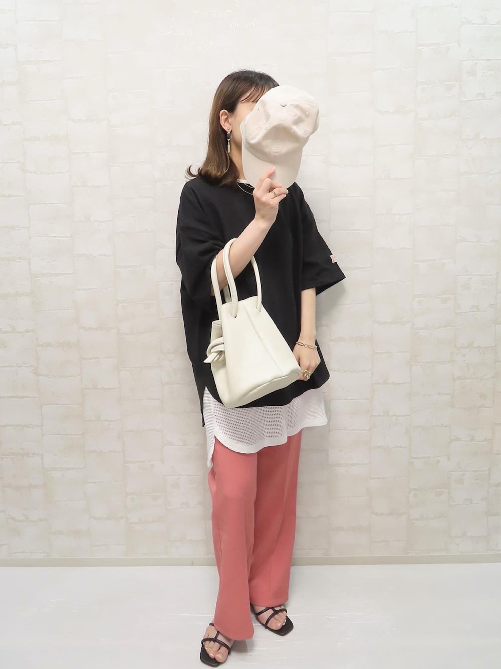 ブラック系のTシャツ/カットソー、ホワイト系のタンクトップ、ピンク系のスラックスを着用したレディースの春コーディネートの1枚目の写真