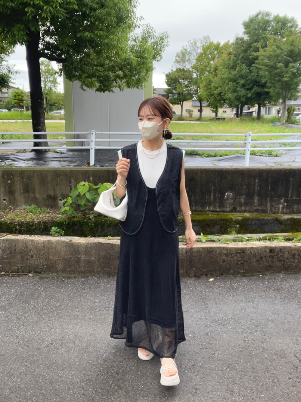 ブラック系のベスト、ホワイト系のニット/セーター、ブラック系のワンピースを着用したレディースの夏コーディネートの1枚目の写真