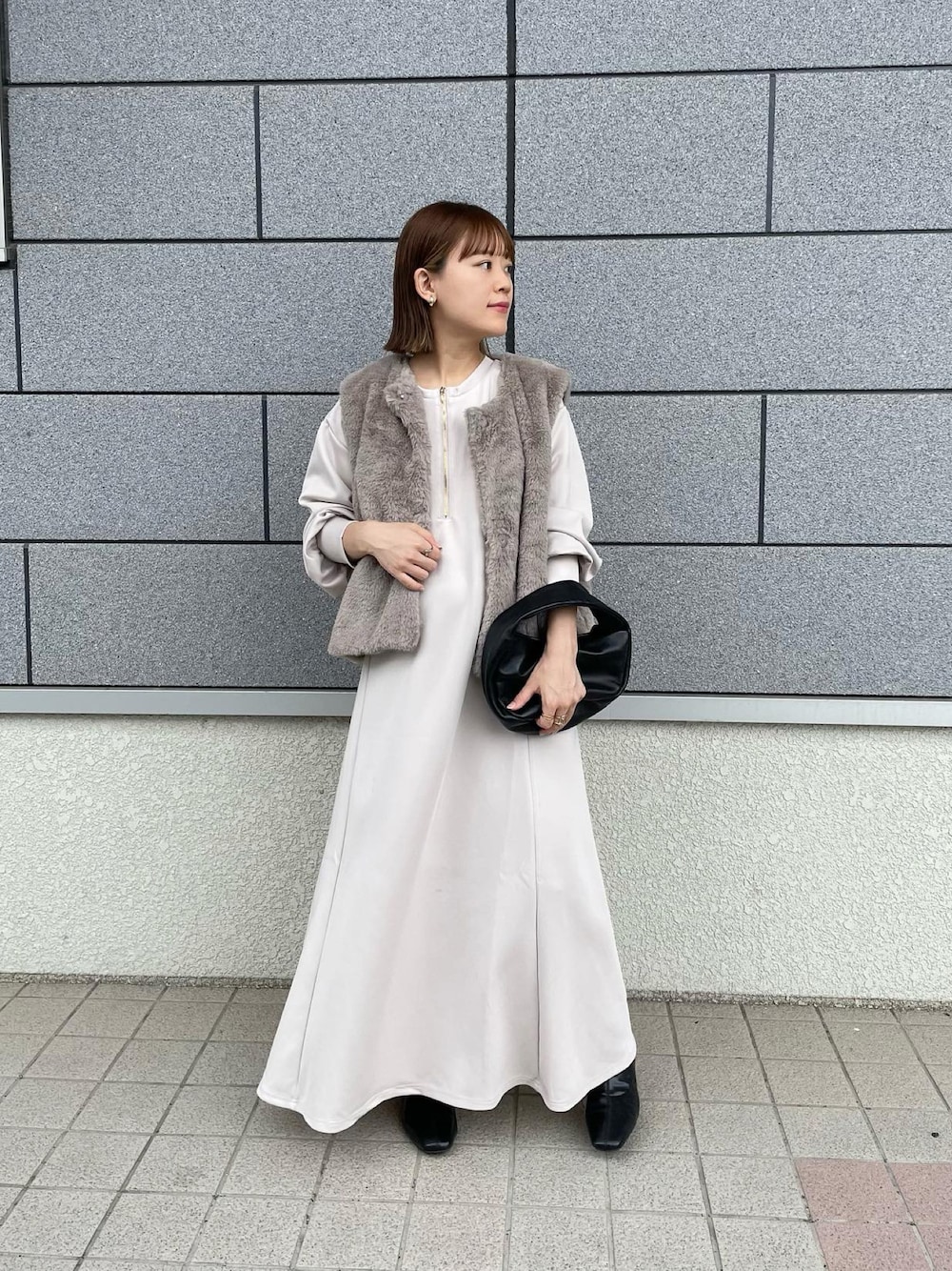 ホワイト系のワンピース、ベージュ系のその他アウター、ブラック系のハンドバッグを着用したレディースの秋コーディネートの1枚目の写真