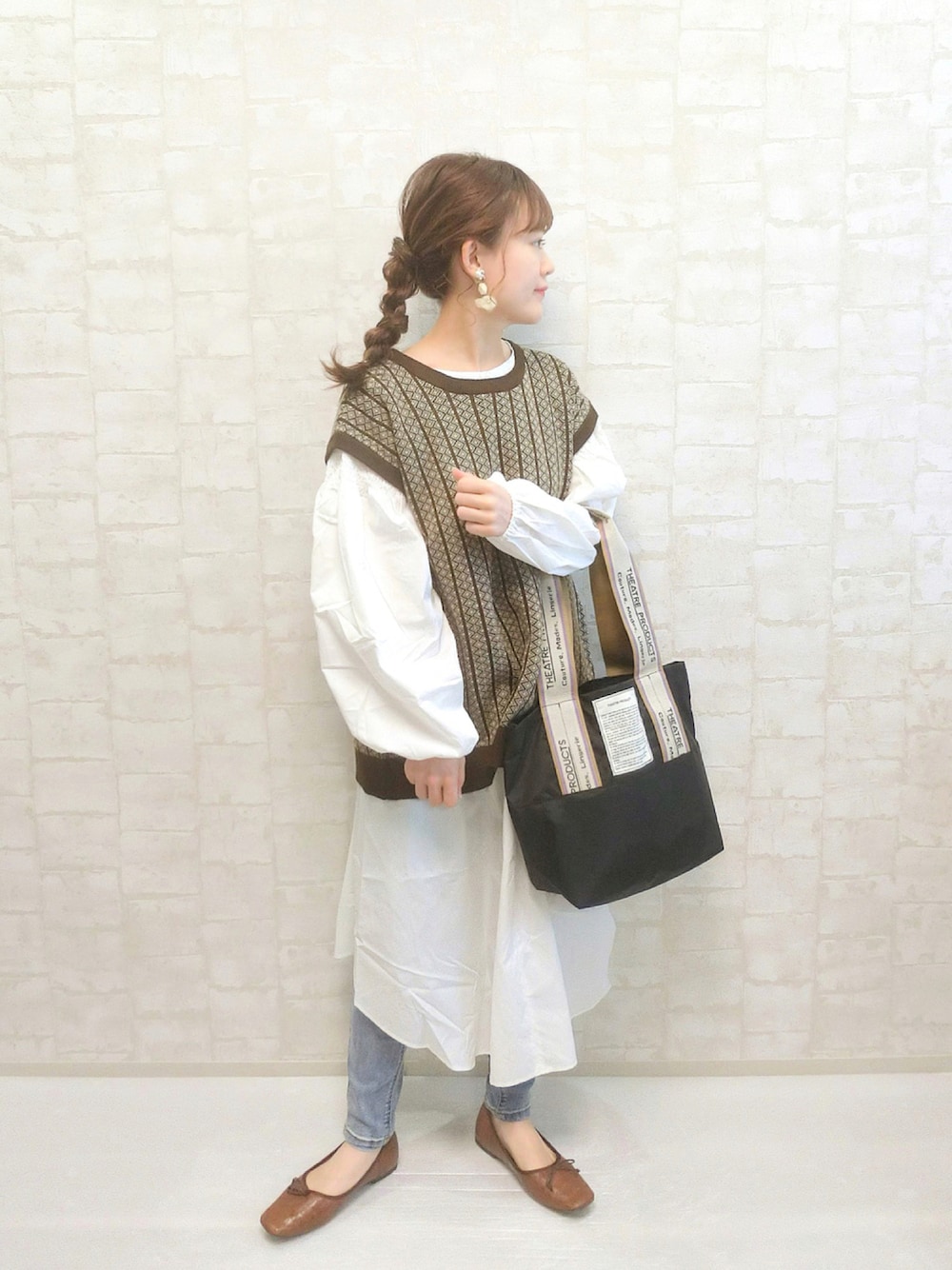 ブラック系のトートバッグ、ブラウン系のベスト、ホワイト系のシャツワンピースを着用したレディースの秋コーディネートの1枚目の写真