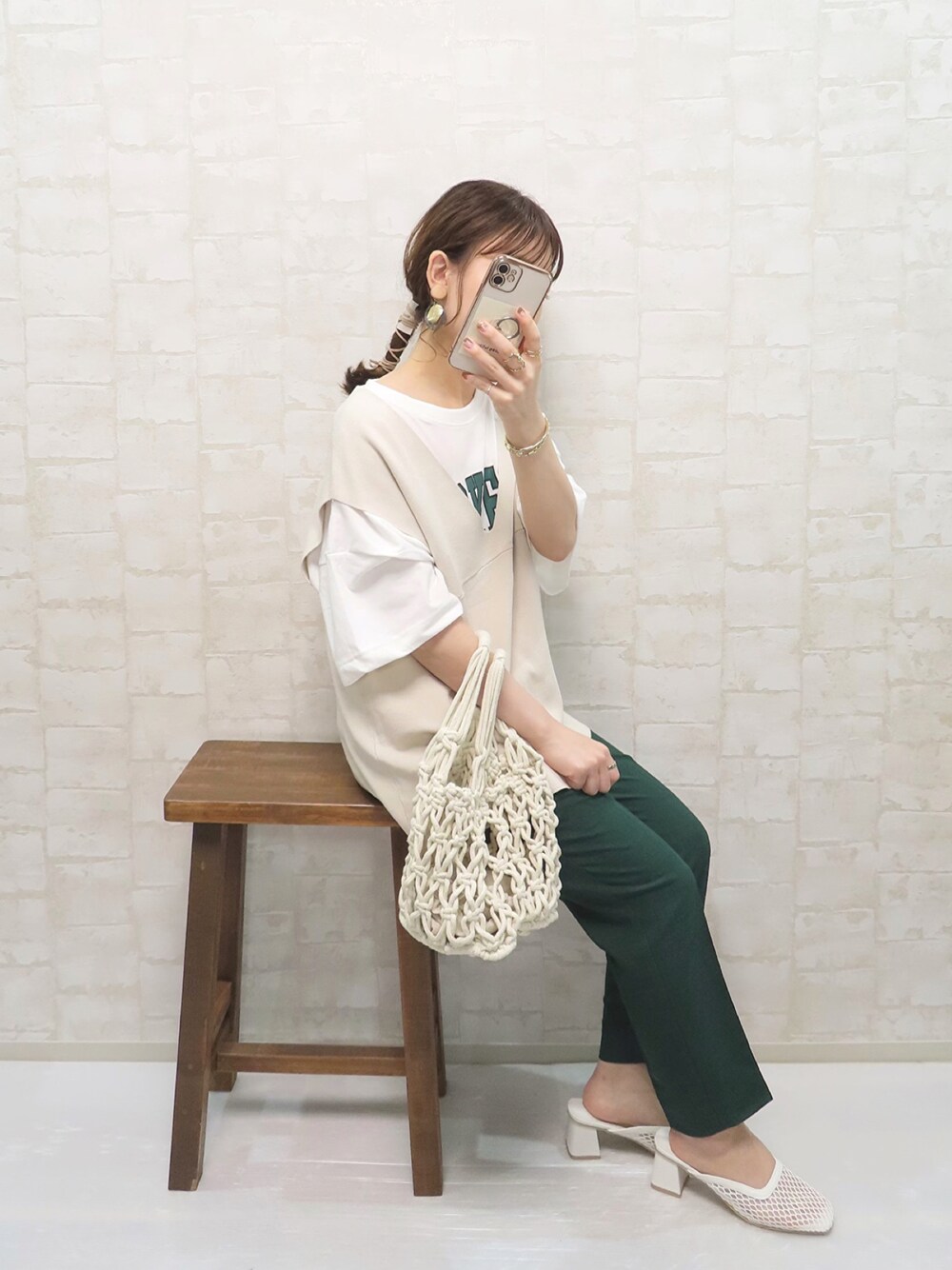 グリーン系のその他パンツ、ホワイト系のハンドバッグ、ホワイト系のサンダルを着用したレディースの春コーディネートの1枚目の写真