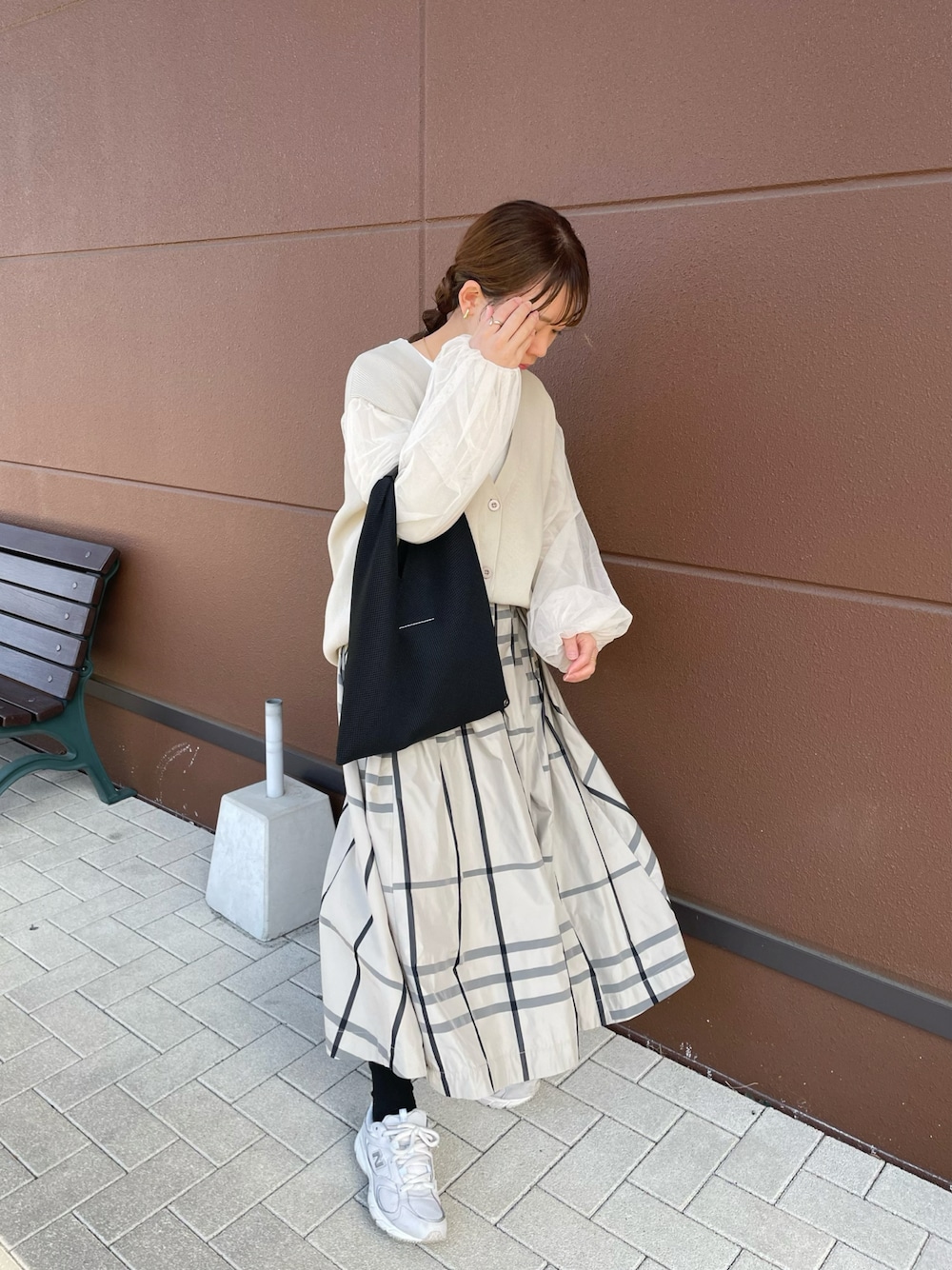 ベージュ系のスカート、ベージュ系のカーディガン/ボレロ、ブラック系のトートバッグを着用したレディースの春コーディネートの1枚目の写真