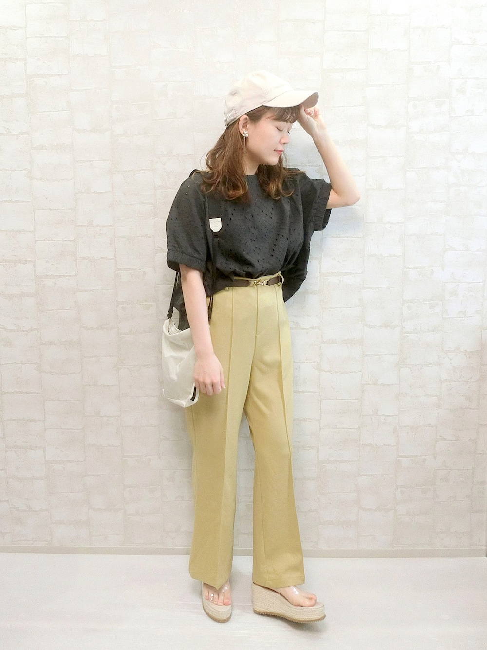 ブラック系のシャツ/ブラウス、イエロー系のパンツ、ベージュ系のショルダーバッグを着用したレディースの夏コーディネートの1枚目の写真