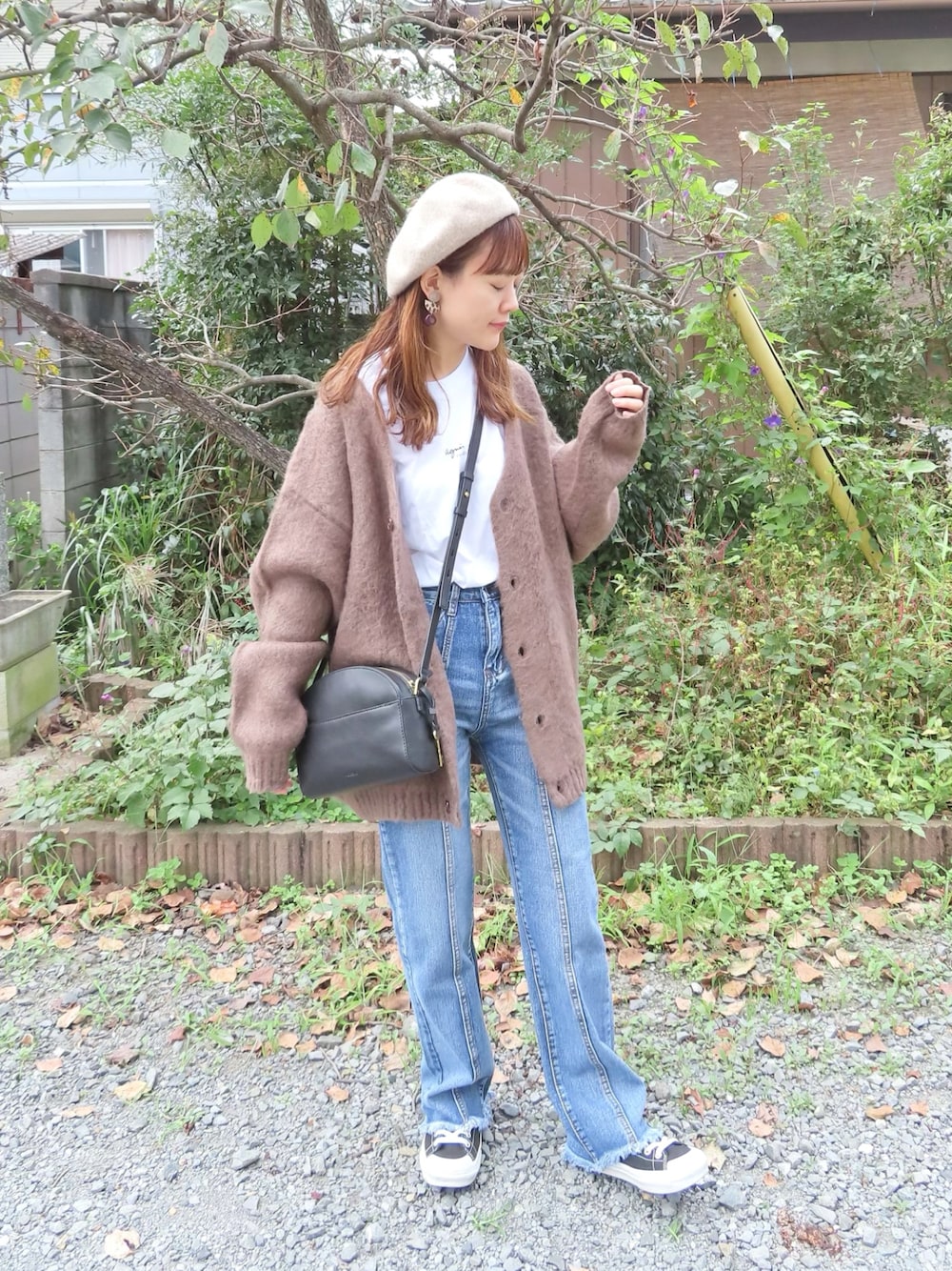 ブラウン系のカーディガン/ボレロ、ブルー系のデニムパンツ、ホワイト系のTシャツ/カットソーを着用したレディースの秋コーディネートの1枚目の写真