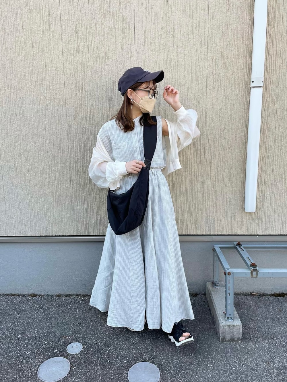 グレー系のシャツ/ブラウス、グレー系のスカート、ブラック系のショルダーバッグを着用したレディースの春コーディネートの1枚目の写真