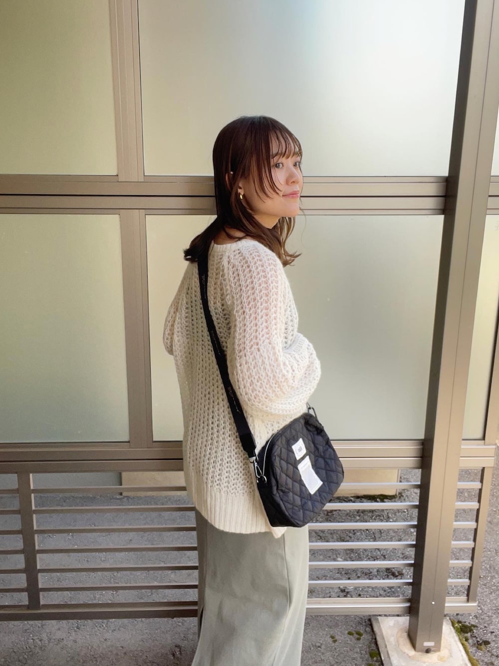 ホワイト系のカーディガン/ボレロ、ブラック系のショルダーバッグ、グリーン系のワンピース/ドレスを着用したレディースの春コーディネートの1枚目の写真