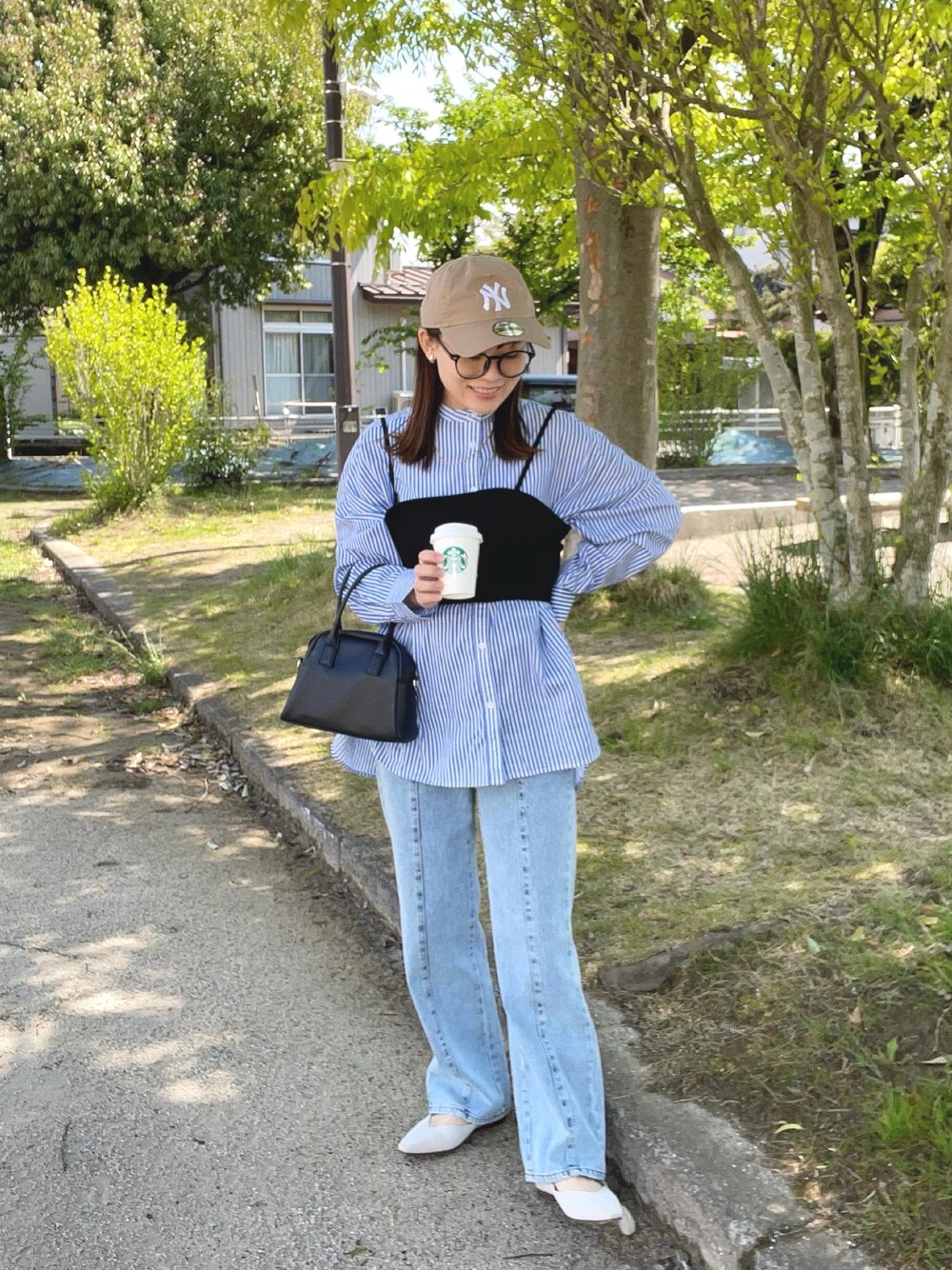 ブルー系のシャツ/ブラウス、ブラック系のその他トップス、ブルー系のデニムパンツを着用したレディースの春コーディネートの1枚目の写真