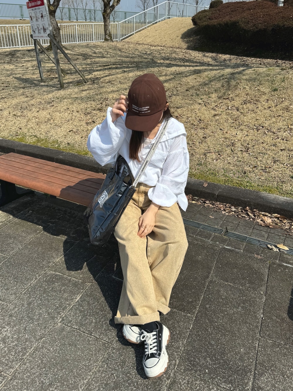 ホワイト系のシャツ/ブラウス、ブラック系のトートバッグ、ベージュ系のパンツを着用したレディースの春コーディネートの1枚目の写真