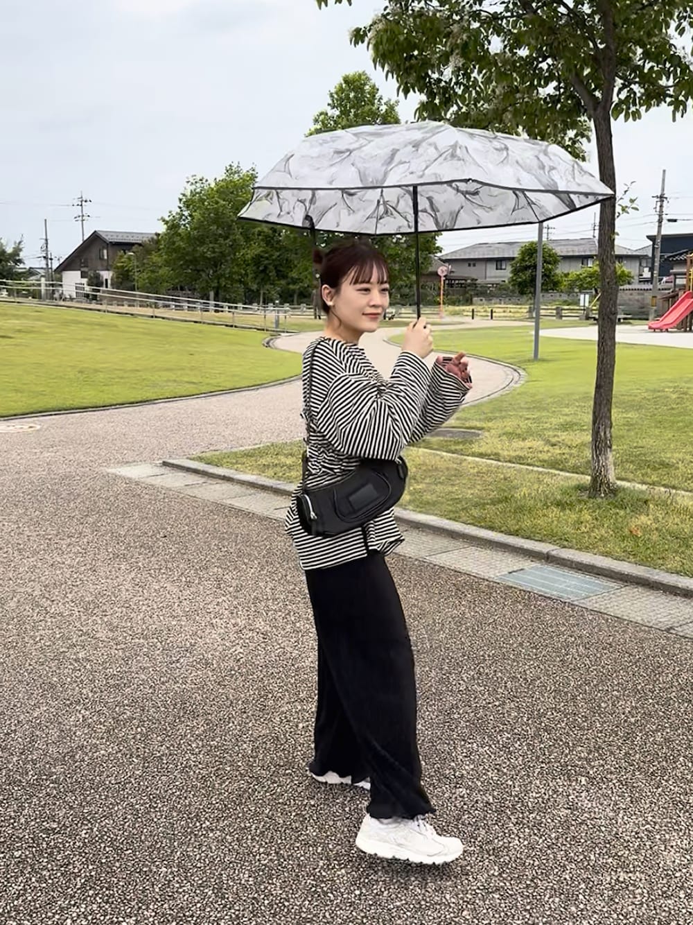 ブラック系のTシャツ/カットソー、ブラック系のその他パンツ、ホワイト系のスニーカーを着用したレディースの春コーディネートの1枚目の写真
