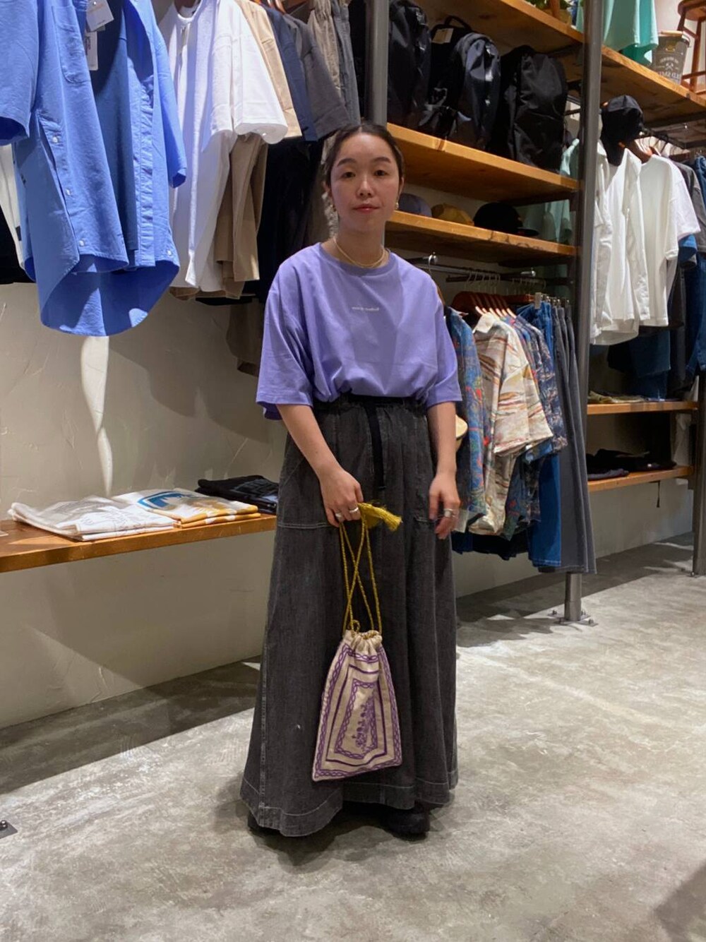 パープル系のショルダーバッグ、パープル系のTシャツ/カットソー、グレー系のスカートを着用したレディースの夏コーディネートの1枚目の写真