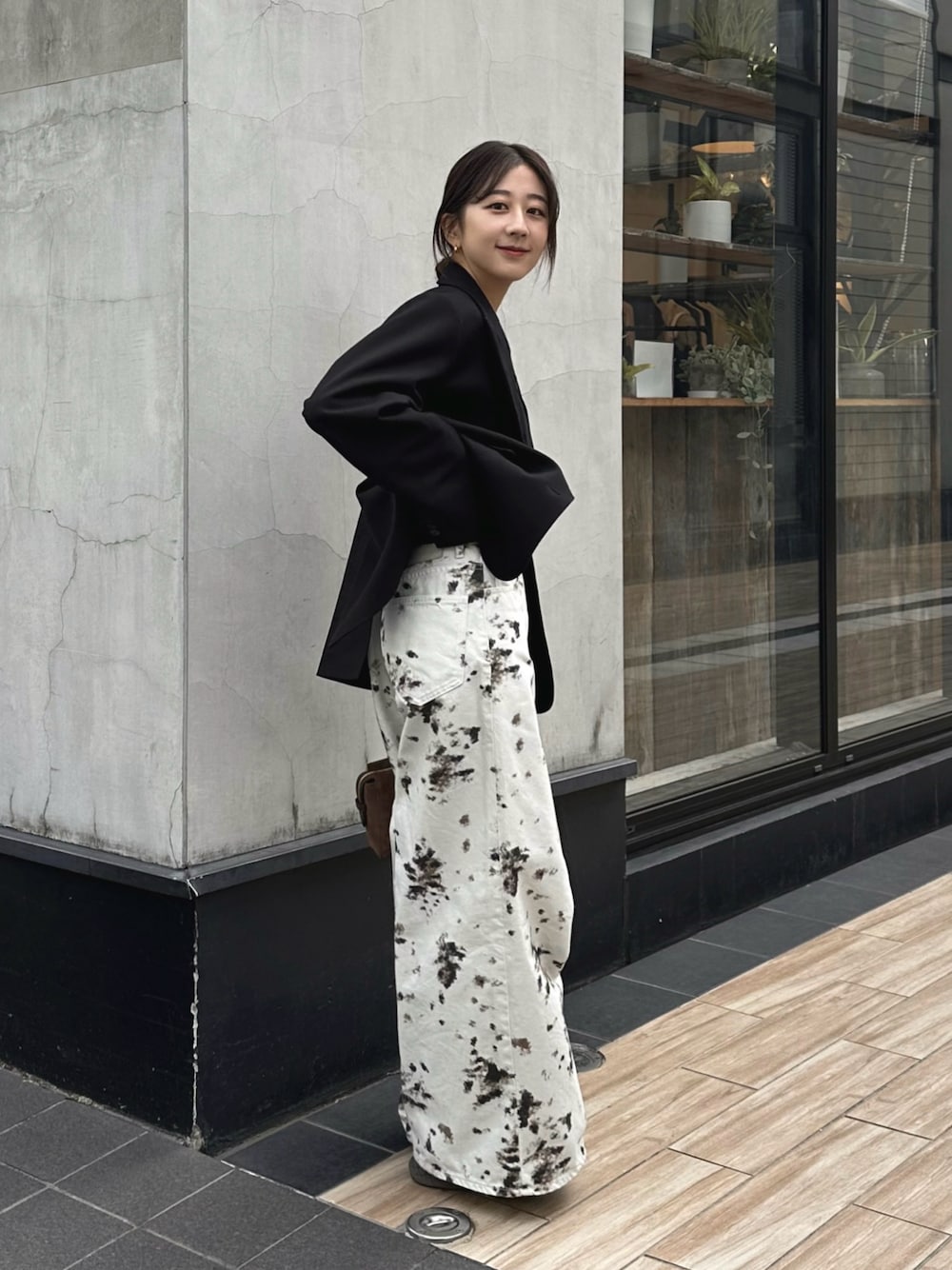 ホワイト系のデニムパンツ、ブラック系のテーラードジャケット、ブラウン系のトートバッグを着用したレディースの秋コーディネートの1枚目の写真