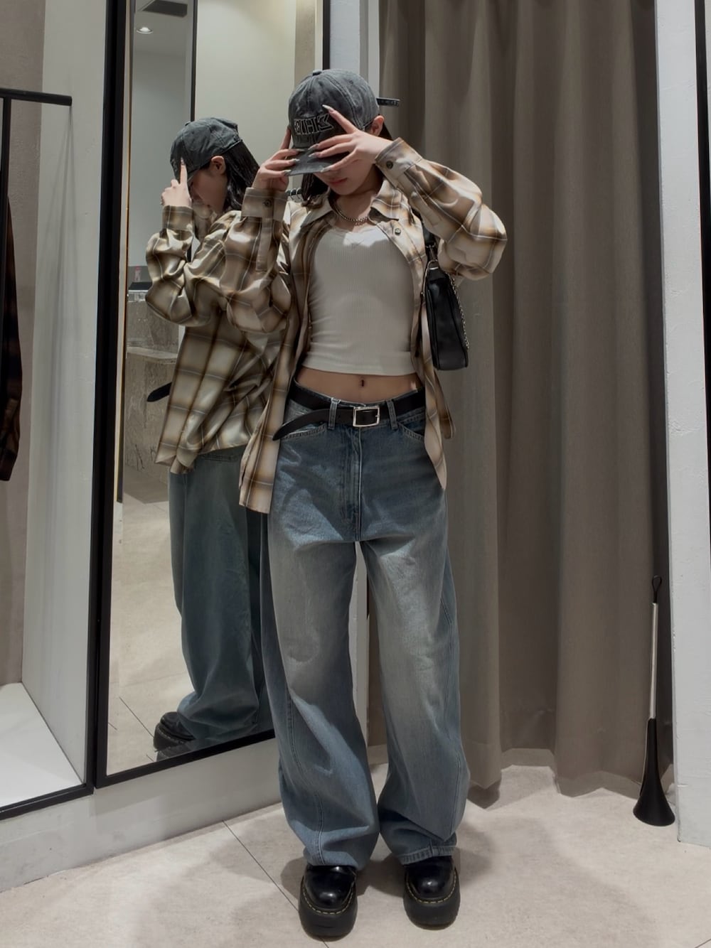 ブルー系のデニムパンツ、ホワイト系のシャツ/ブラウス、ブラック系のショルダーバッグを着用したレディースの春コーディネートの1枚目の写真