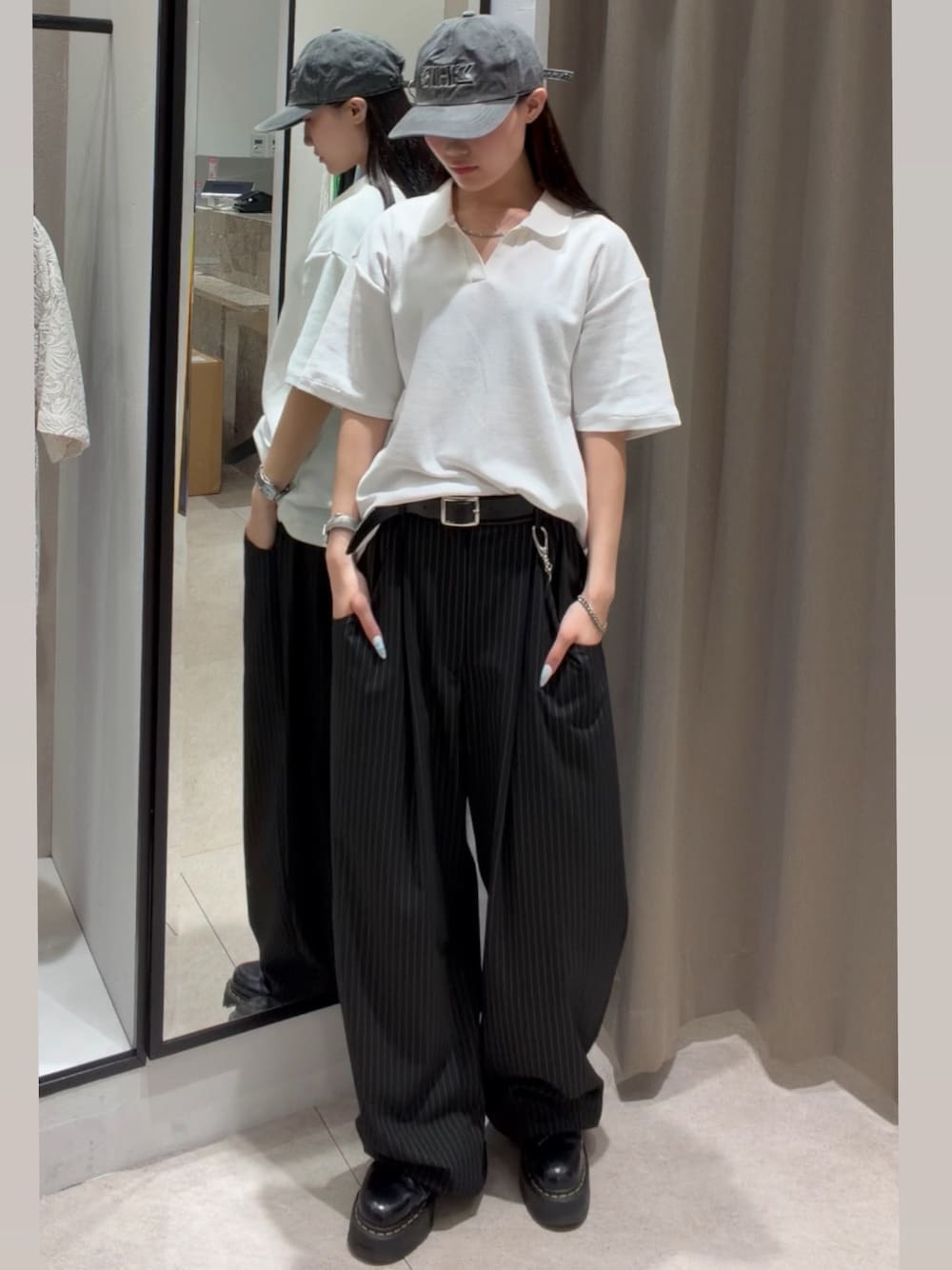 ブラック系のスラックス、ホワイト系のTシャツ/カットソー、ブラック系のキャップを着用したレディースの春コーディネートの1枚目の写真