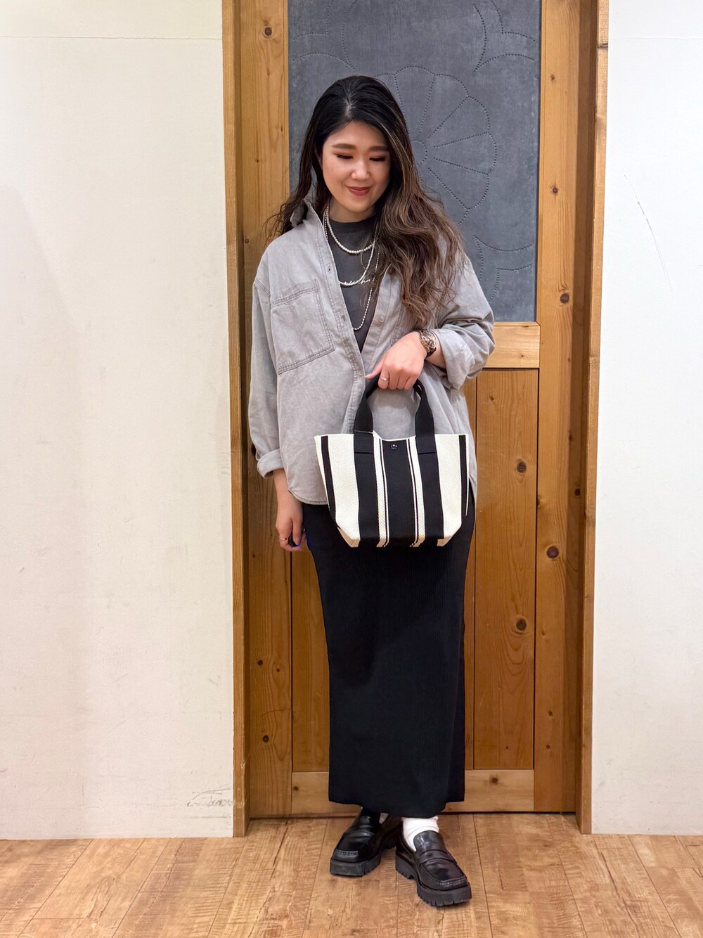 グレー系のシャツ/ブラウス、グレー系のTシャツ/カットソー、ブラック系のスカートを着用したレディースの春コーディネートの1枚目の写真