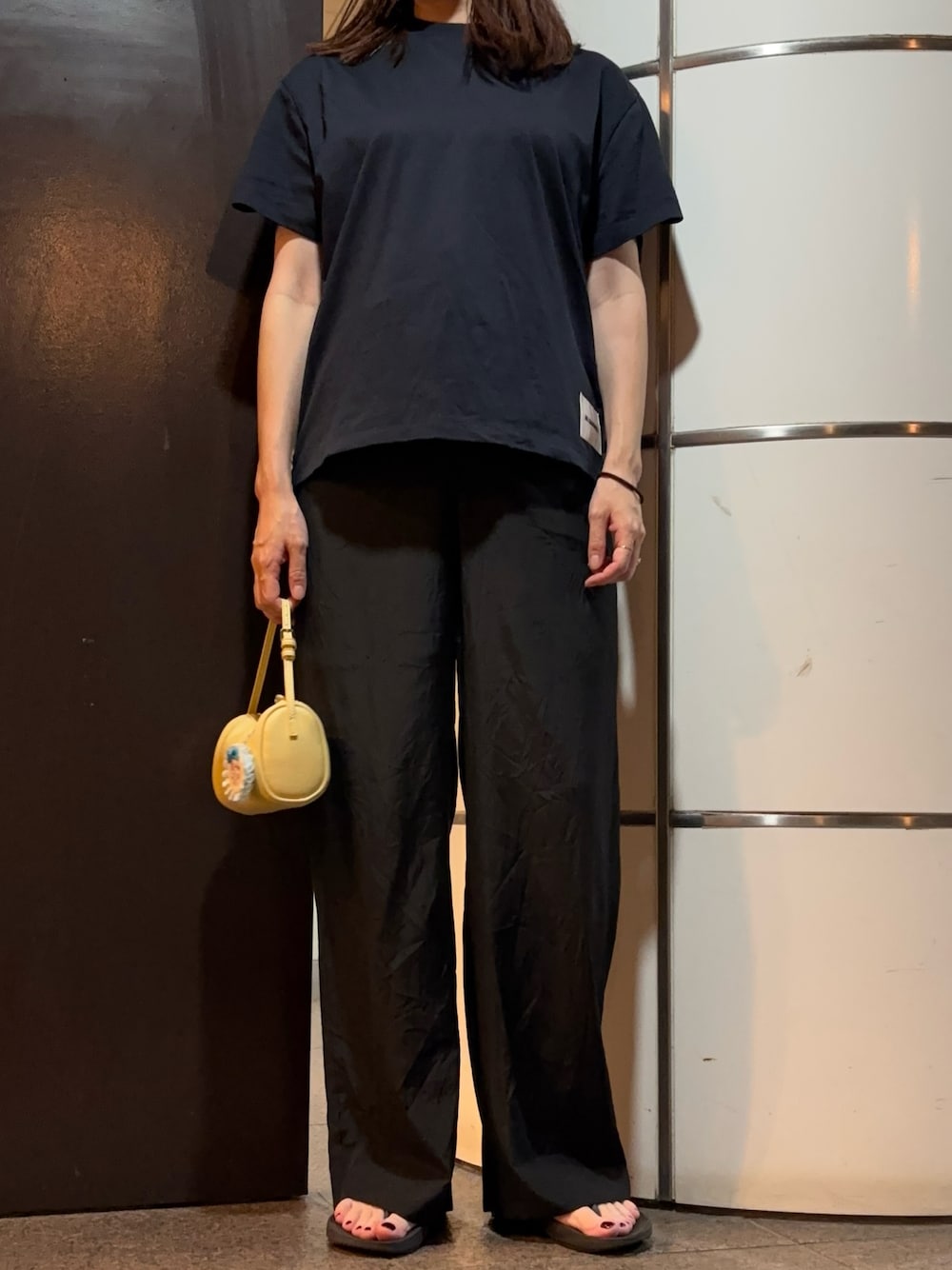 ブラック系のその他パンツ、ブルー系のTシャツ/カットソー、ブラック系のサンダルを着用したレディースの秋コーディネートの1枚目の写真