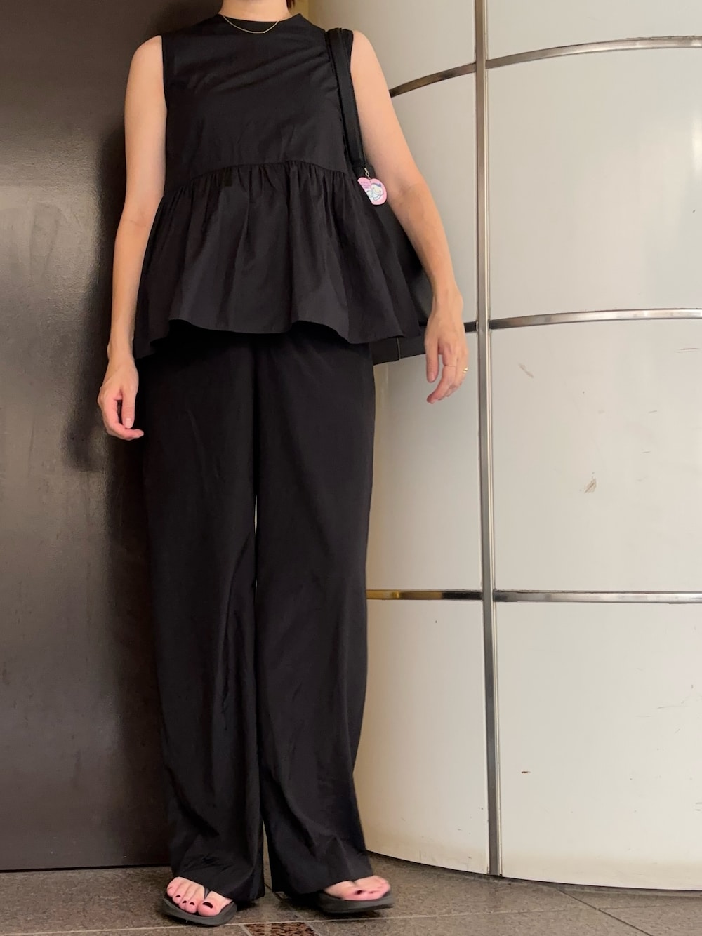 ブラック系のその他パンツ、ブラック系のトートバッグ、ブラック系のサンダルを着用したレディースの秋コーディネートの1枚目の写真