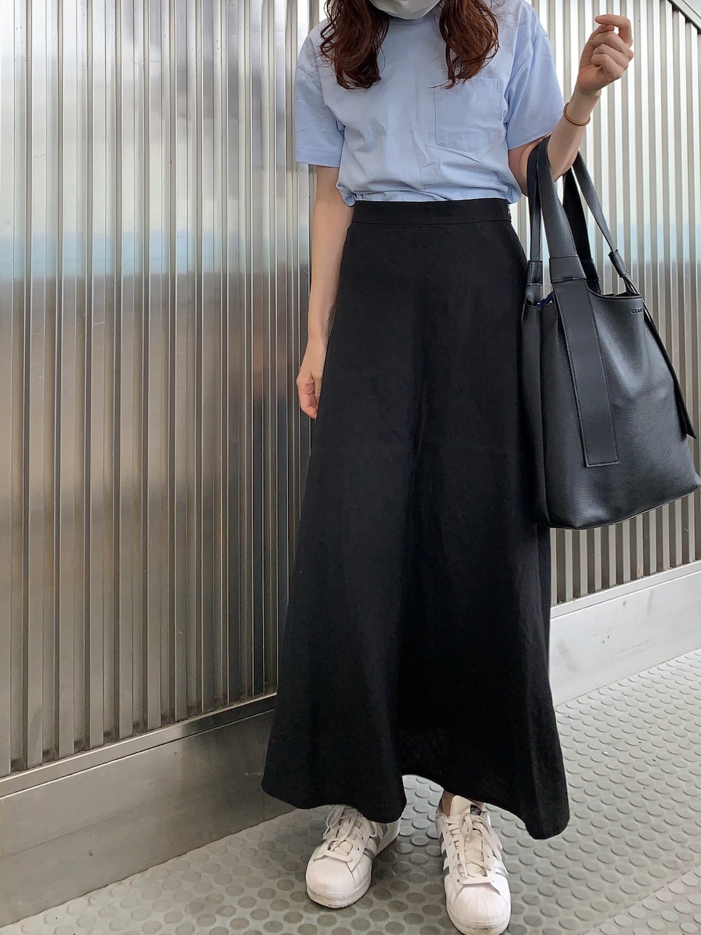 ブルー系のTシャツ/カットソー、ブラック系のスカート、ホワイト系のスニーカーを着用したレディースの夏コーディネートの1枚目の写真