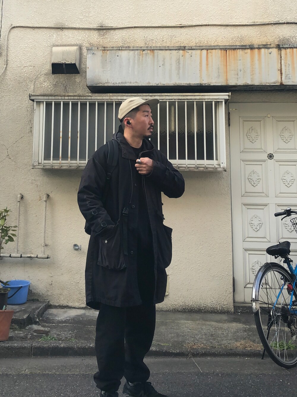ブラック系のマウンテンパーカー、ブラック系のスウェットパンツ、ブラック系のスニーカーを着用したメンズの冬コーディネートの1枚目の写真