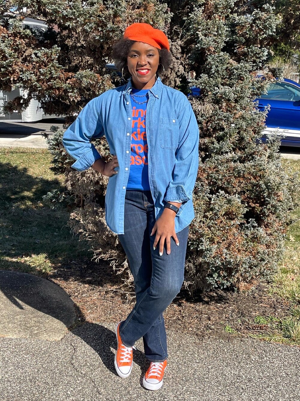 ブルー系のデニムパンツ、オレンジ系のスニーカーを着用したレディースの春コーディネートの1枚目の写真