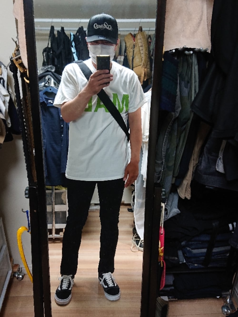 ブラック系のスニーカー、ブラック系のデニムパンツ、グリーン系のTシャツ/カットソーを着用したメンズの秋コーディネートの1枚目の写真