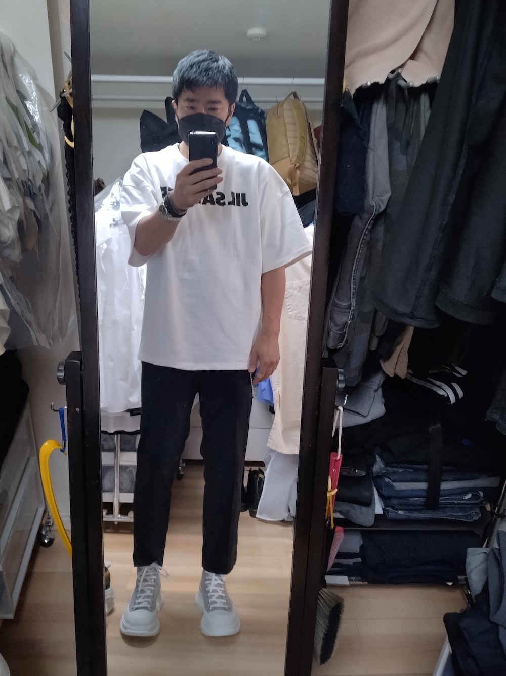 ホワイト系のスニーカー、ブラック系のスラックス、ホワイト系のTシャツ/カットソーを着用したメンズの夏コーディネートの1枚目の写真