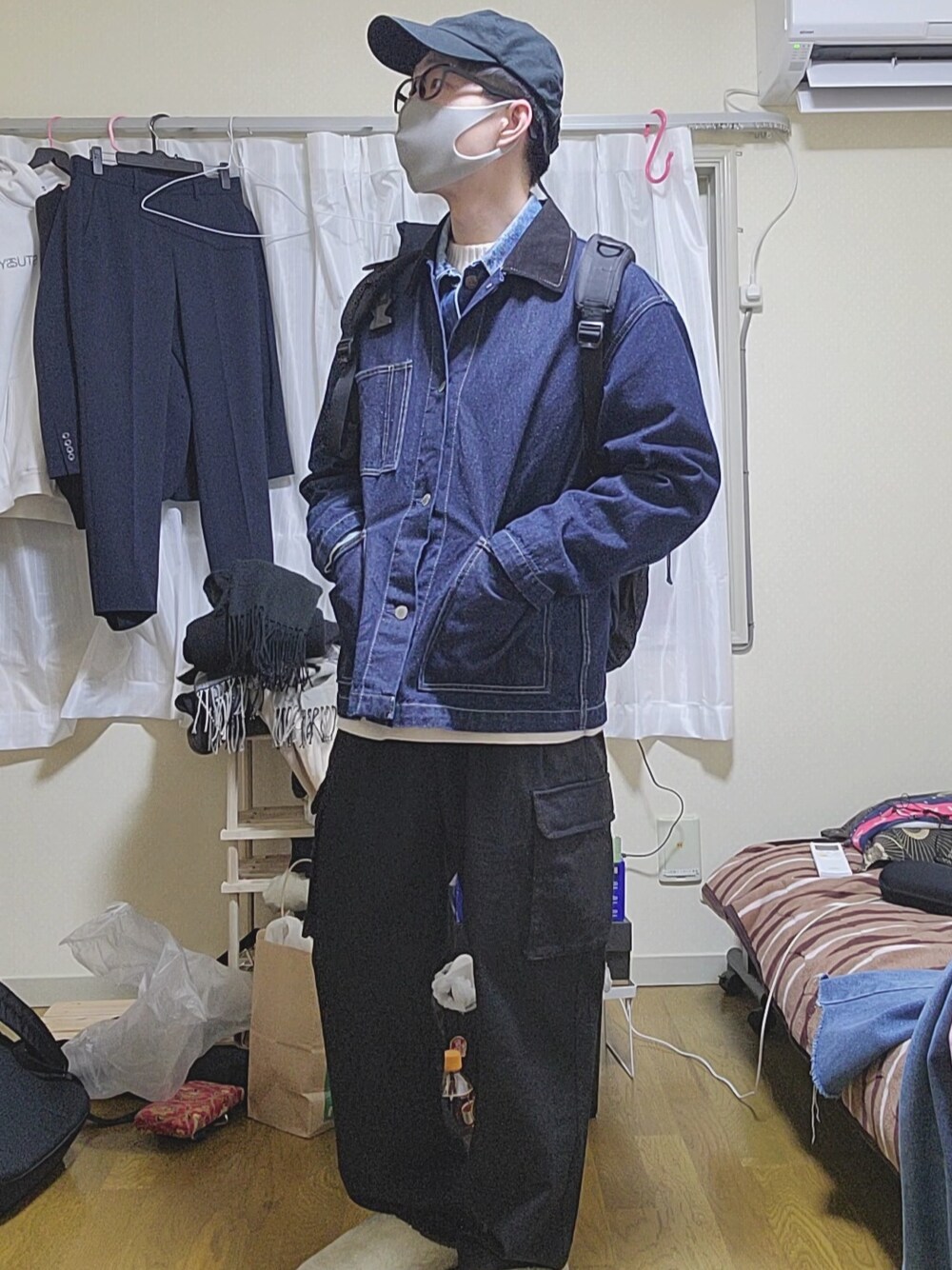 ブルー系のカバーオール、ブルー系のデニムジャケット、ホワイト系のニット/セーターを着用したメンズの冬コーディネートの1枚目の写真