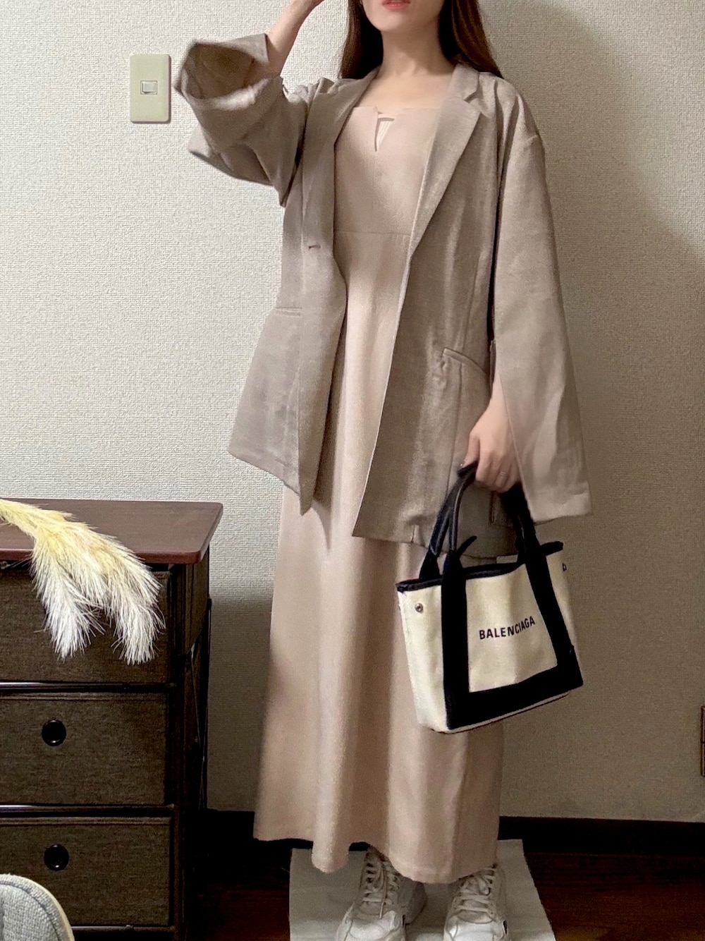 ベージュ系のハンドバッグ、ベージュ系のワンピース、ピンク系のテーラードジャケットを着用したレディースの秋コーディネートの1枚目の写真