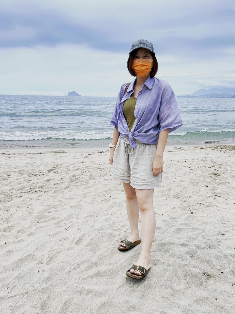 ブルー系のシャツ/ブラウス、グリーン系のサンダル、グレー系のキャップを着用したレディースの夏コーディネートの1枚目の写真