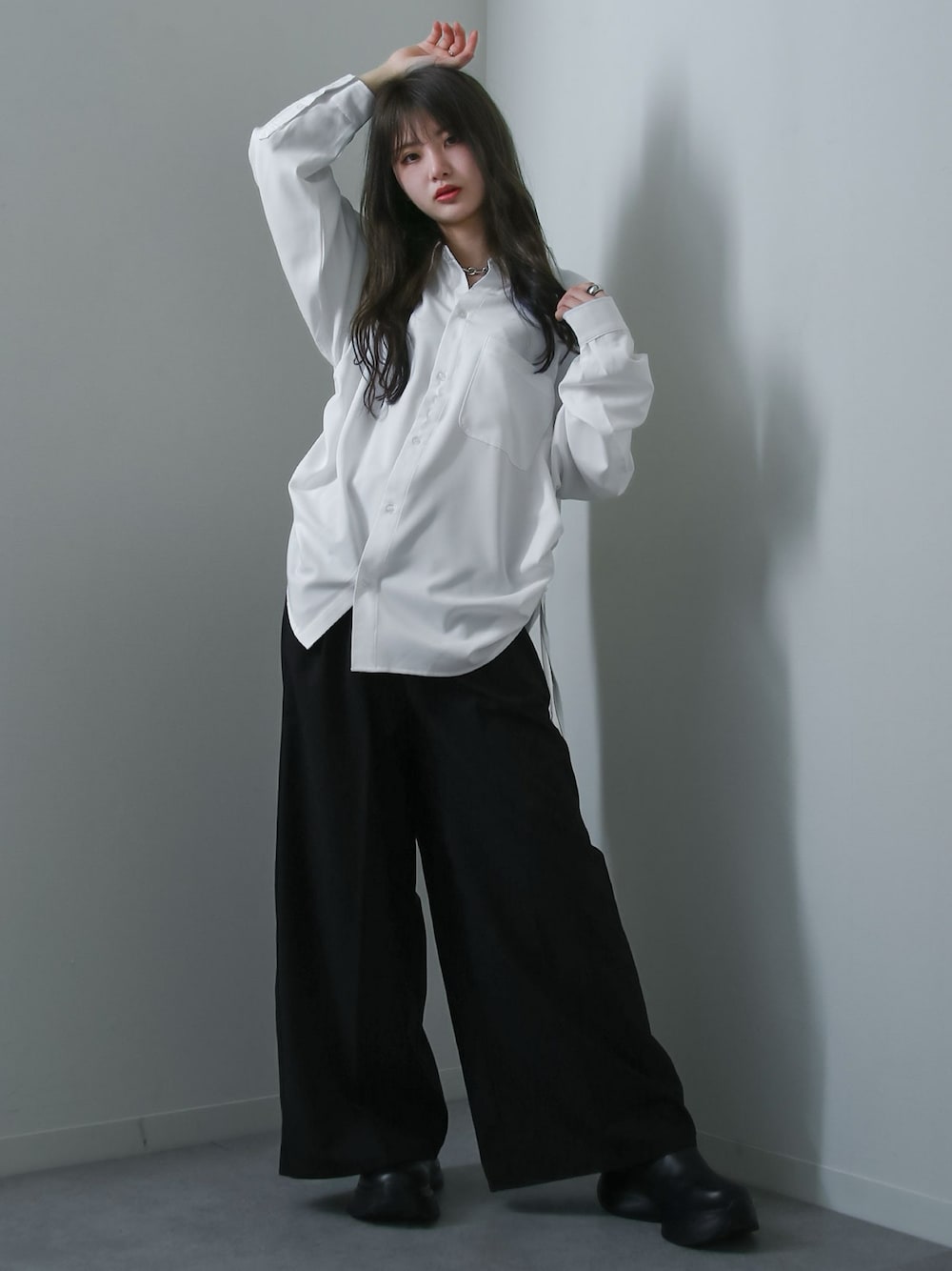 ホワイト系のシャツ/ブラウス、ブラック系のスラックスを着用したレディースの冬コーディネートの1枚目の写真