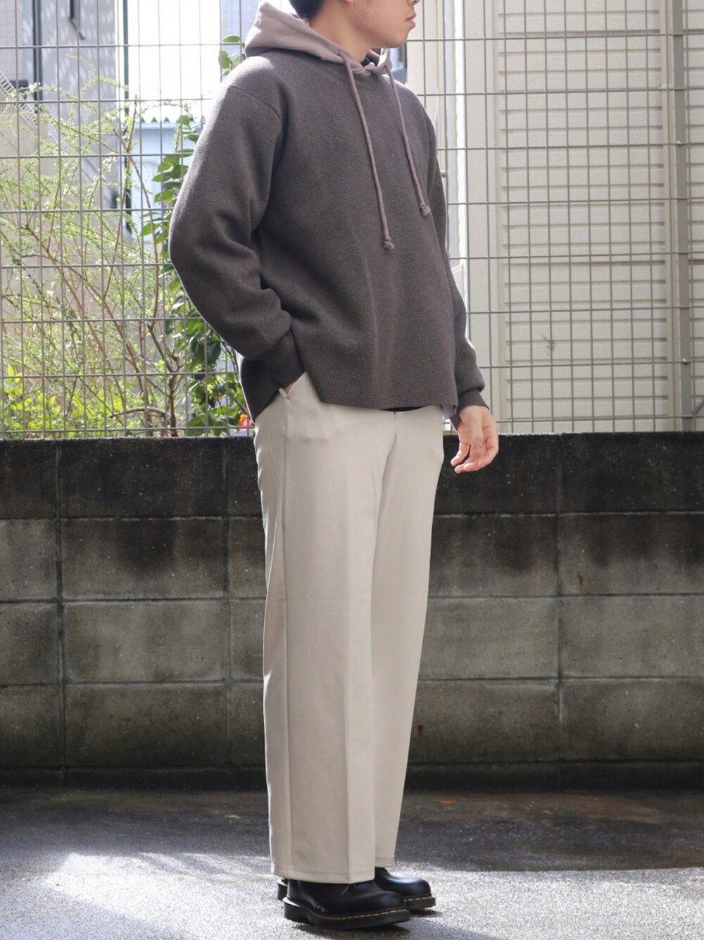 ブラック系のドレスシューズ、ホワイト系のパンツ、ブラウン系のニット/セーターを着用したメンズの秋コーディネートの1枚目の写真