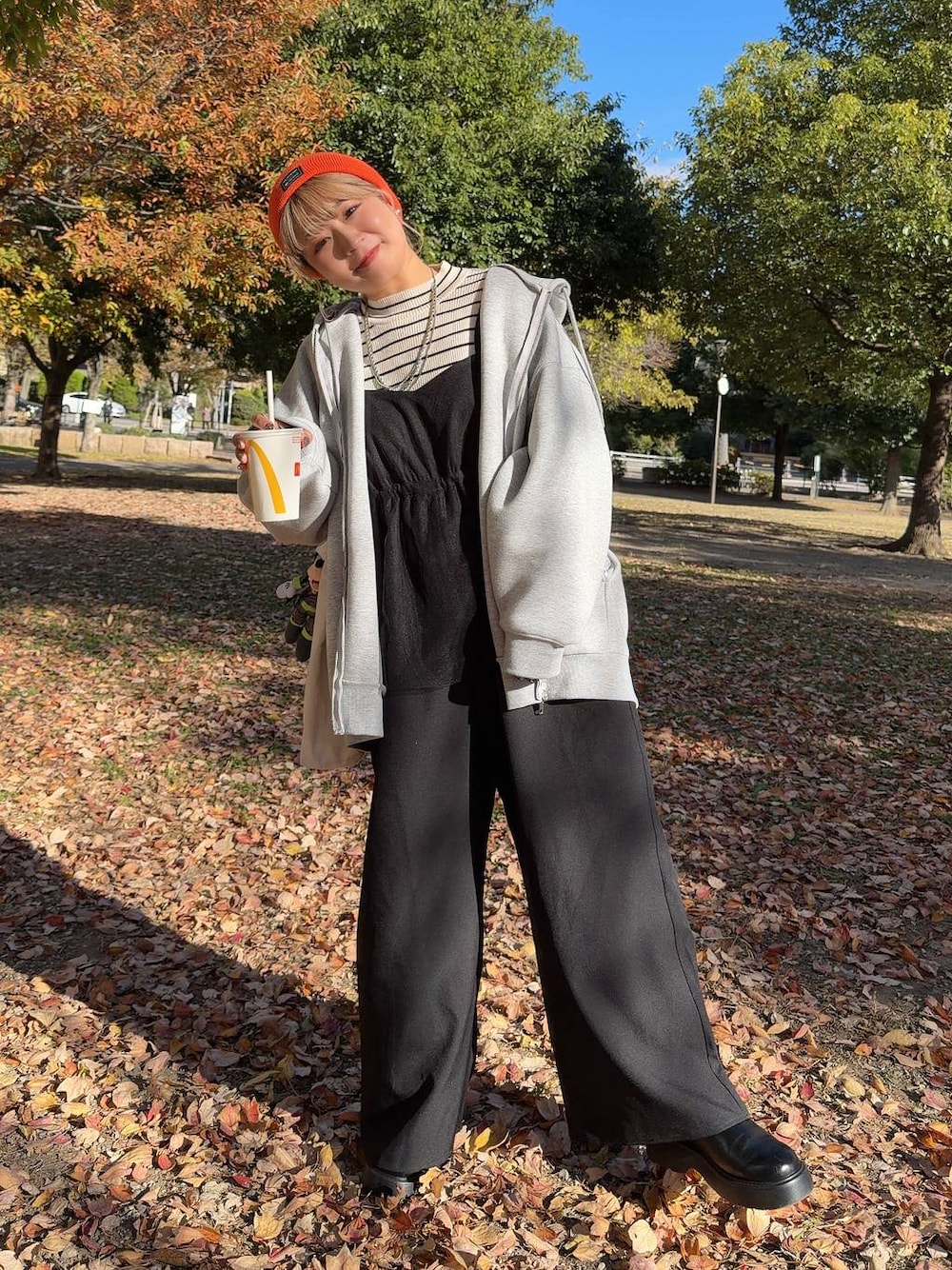 ブラック系のサンダル、ホワイト系のニット/セーター、グレー系のパーカーを着用したレディースの秋コーディネートの1枚目の写真