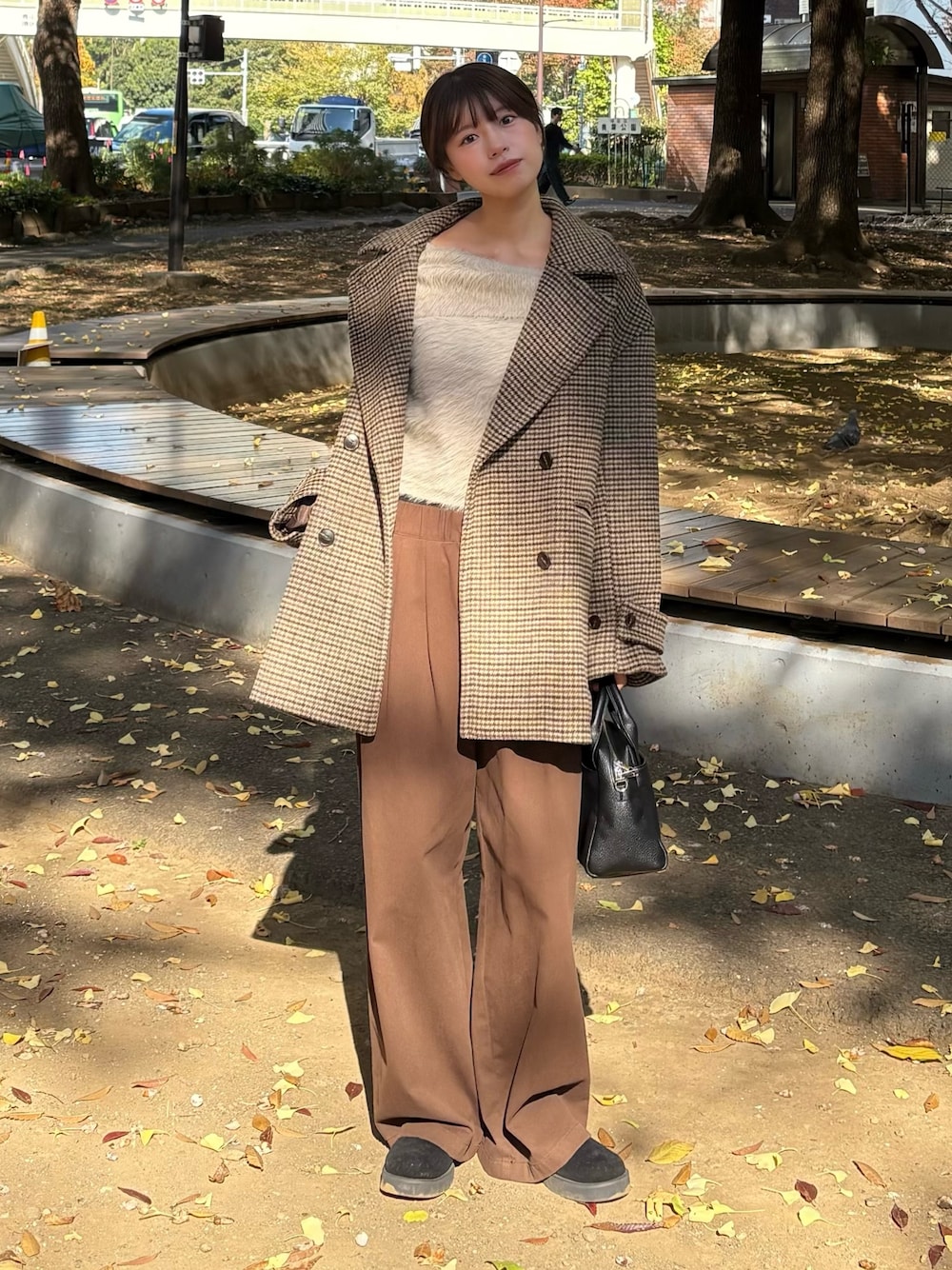 ベージュ系のピーコート、グレー系のニット/セーター、ブラウン系のその他パンツを着用したレディースの秋コーディネートの1枚目の写真