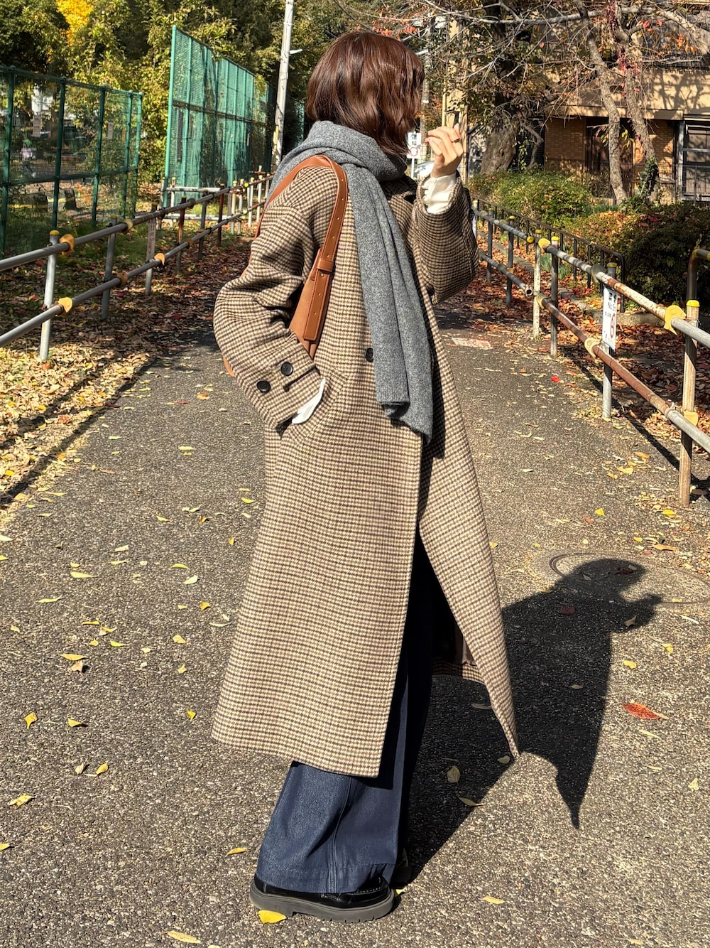 ベージュ系のチェスターコート、ブルー系のデニムパンツ、グレー系のストール/ショールを着用したレディースの秋コーディネートの1枚目の写真