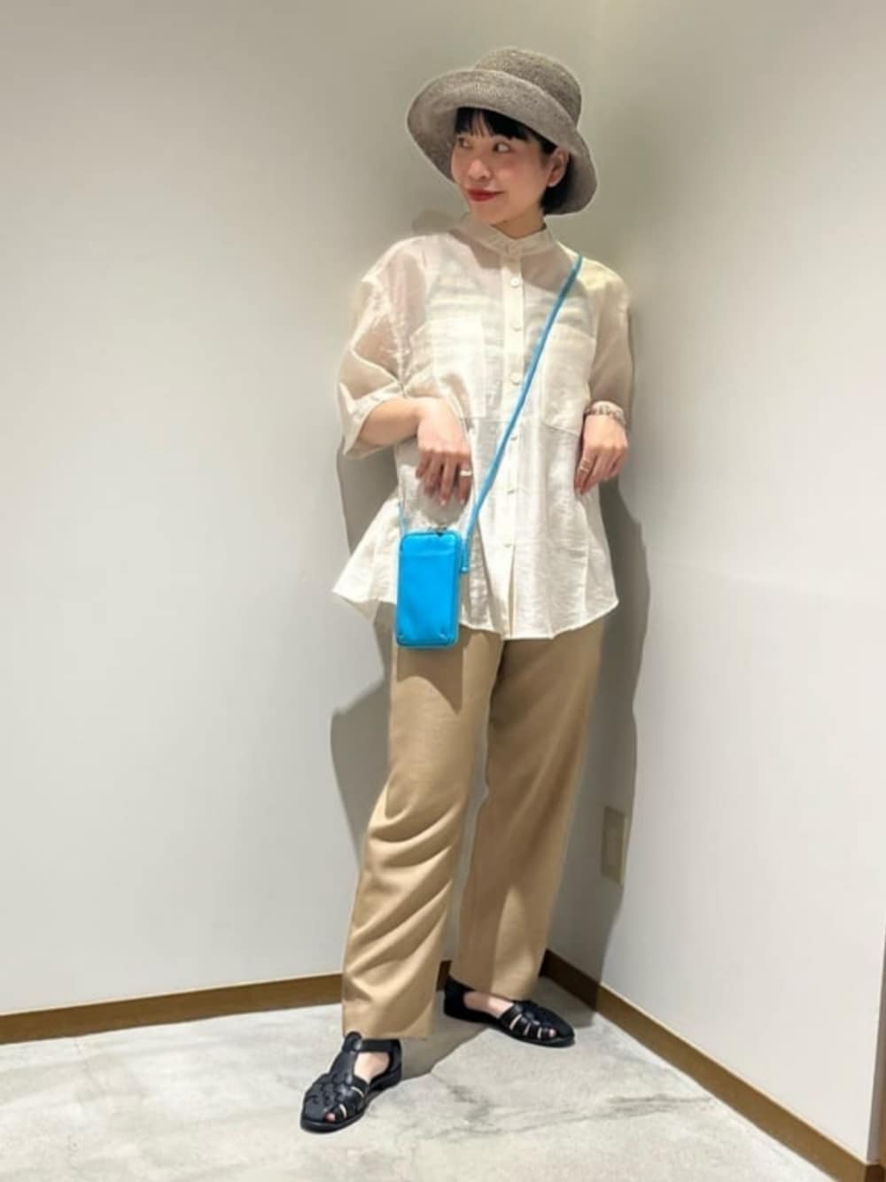 ベージュ系のその他パンツ、ホワイト系のシャツ/ブラウス、ブラック系のサンダルを着用したレディースの春コーディネートの1枚目の写真