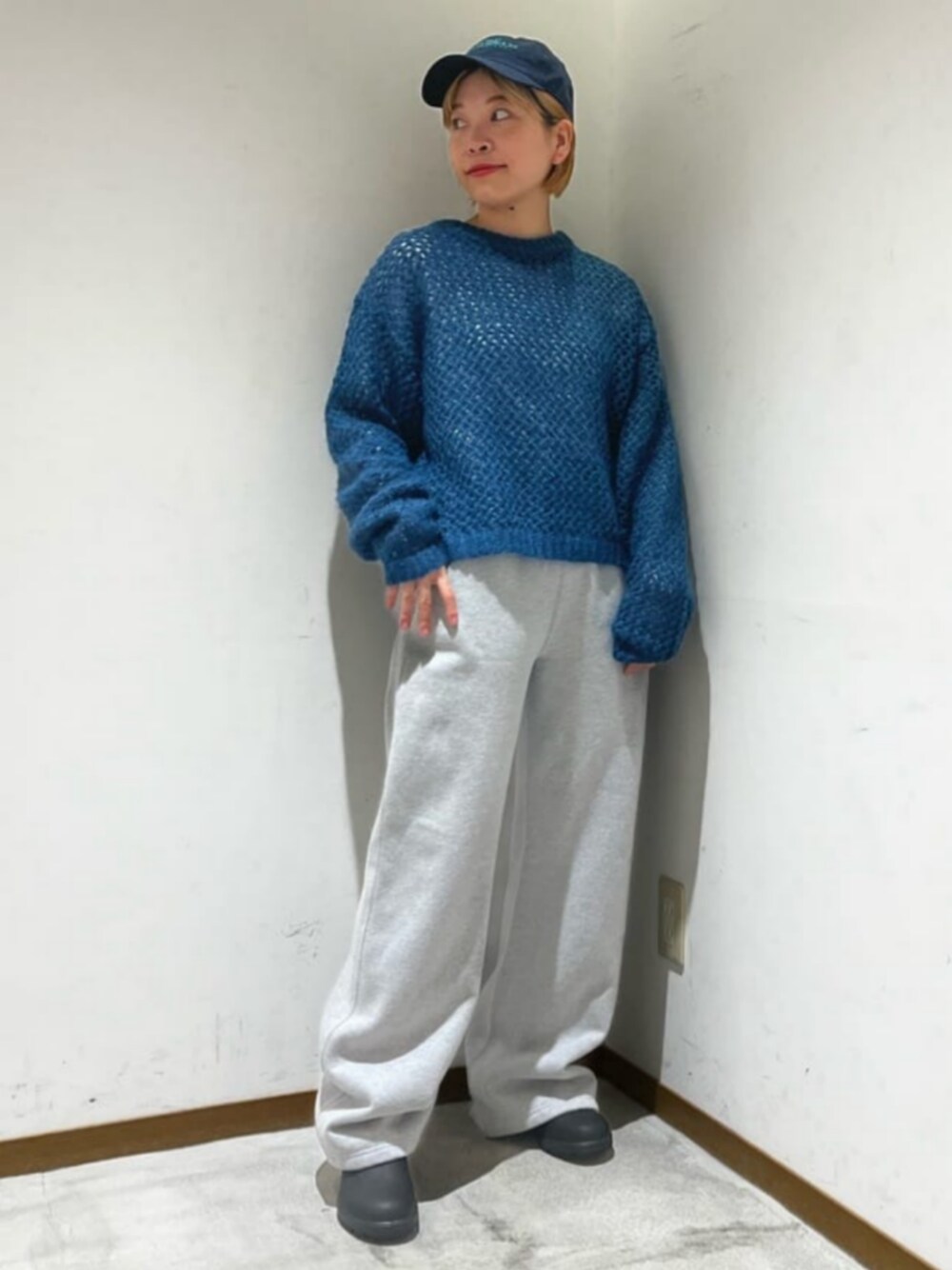 ホワイト系のTシャツ/カットソー、ブルー系のニット/セーター、グレー系のスウェットパンツを着用したレディースの秋コーディネートの1枚目の写真