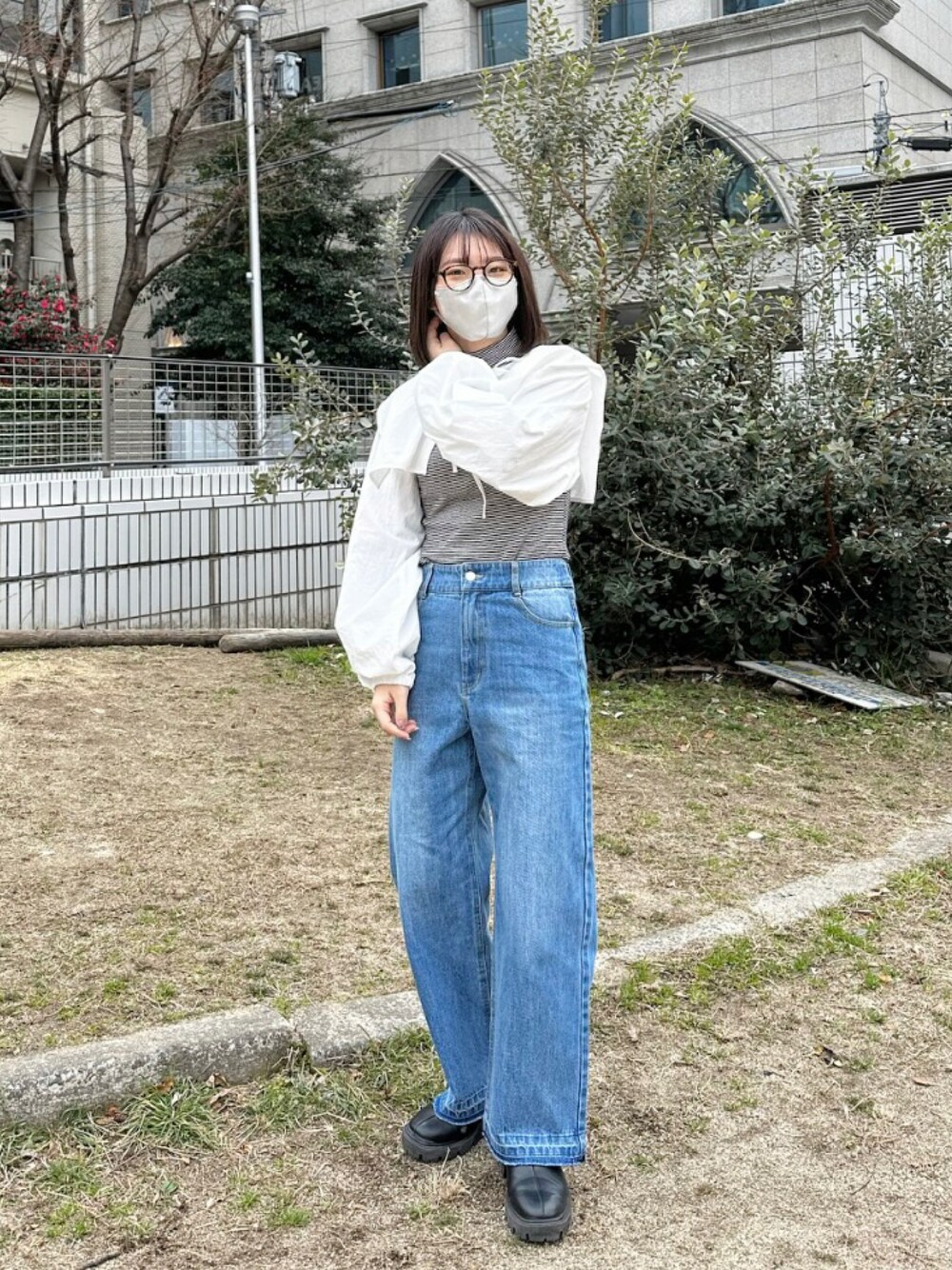 ブラック系のブーツ、ブルー系のデニムパンツ、ホワイト系のシャツ/ブラウスを着用したレディースの冬コーディネートの1枚目の写真