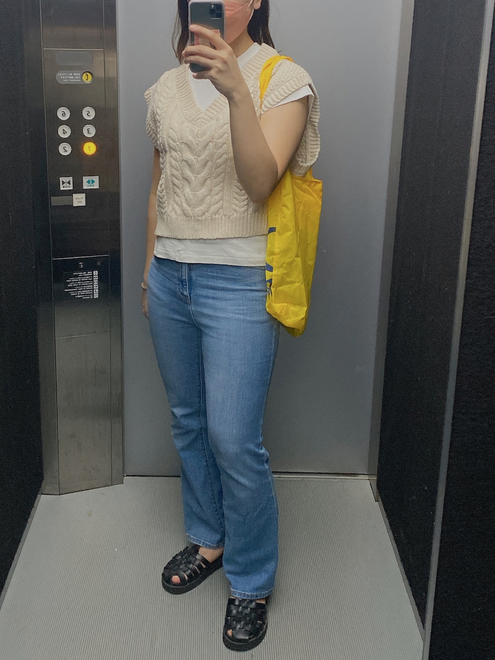 ホワイト系のベスト、ホワイト系のTシャツ/カットソー、ブルー系のデニムパンツを着用したレディースの秋コーディネートの1枚目の写真